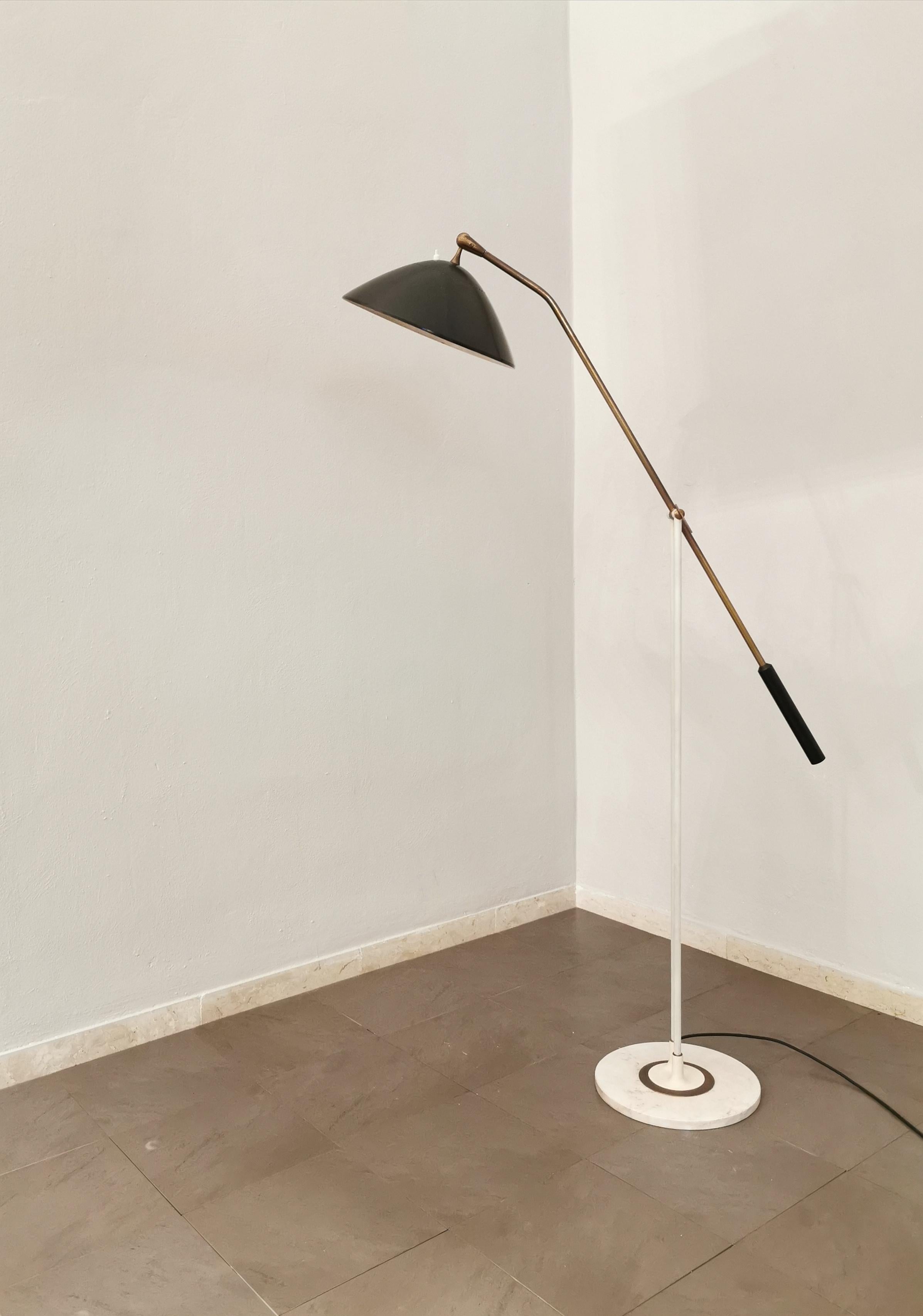Rare floor lamp produced in the 1950s by the renowned Italian company Stilnovo. The lamp has a circular marble base, where 2 white enamelled metal rods rise which join the long moving arm in brass with black enamelled aluminum diffuser.