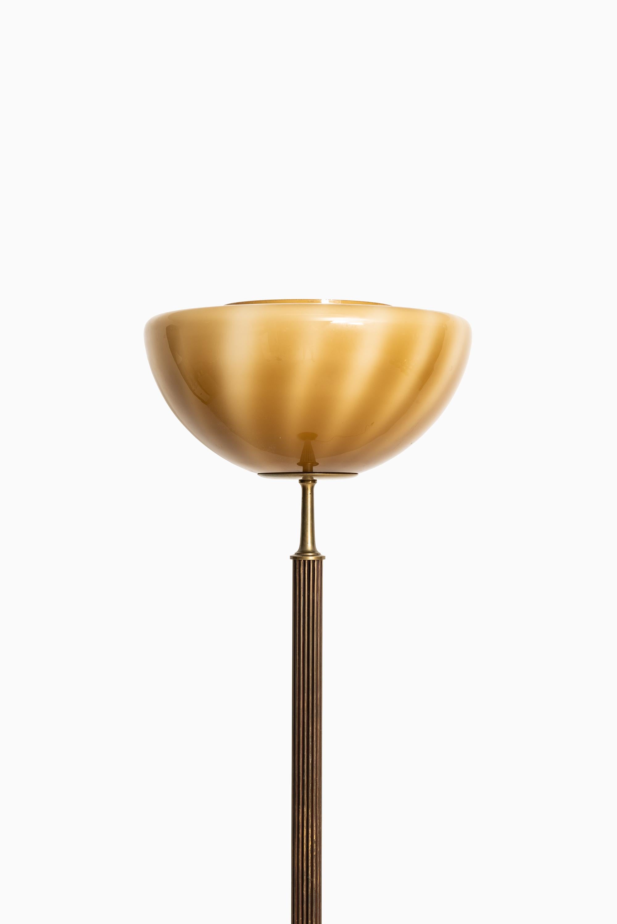 Rare and heavy floor lamp / uplight in brass and glass. Produced in Sweden.