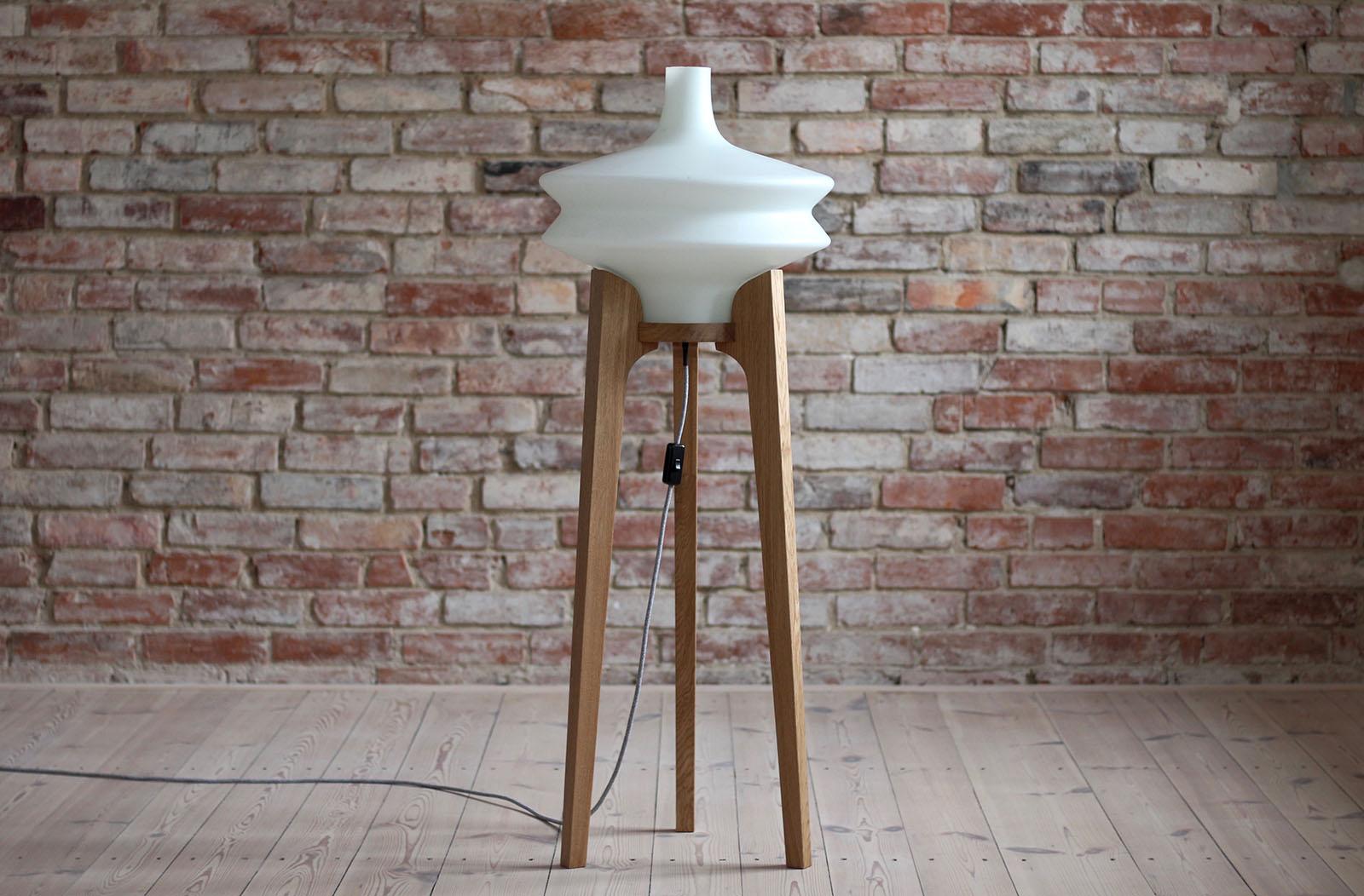 This 1960s floor lamp was made by Czech manufacturer ULUV (Ustredi lidove a umelecke vyroby). It has a large milk-white glass lampshade set on a tripod wooden base. It gives a warm delicate light creating good vibes in the room. The wooden base was
