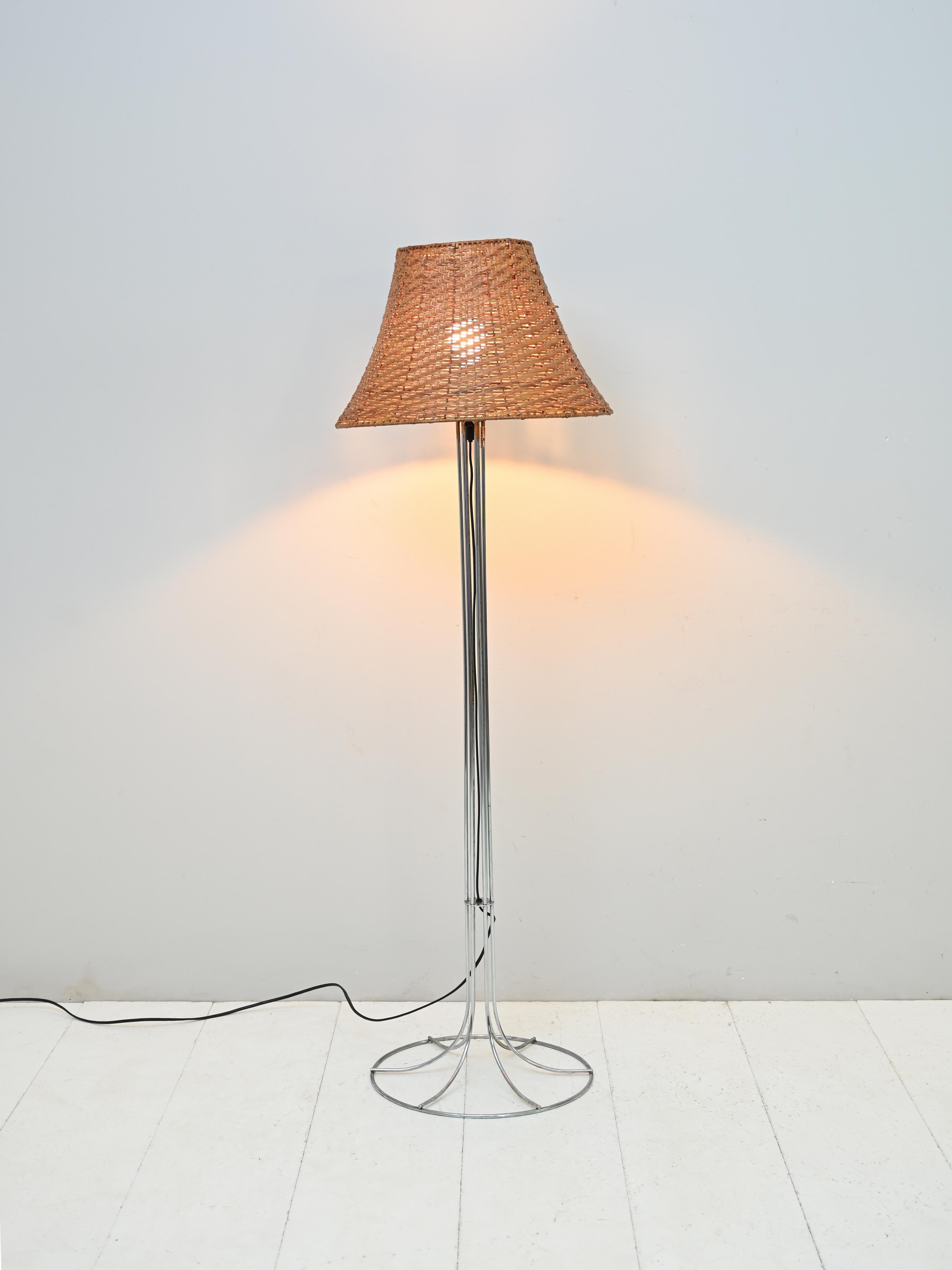 1960er Vintage-Stehlampe.

Eine skandinavische Vintage-Lampe mit Metallsockel und geflochtenem Rattan-Lampenschirm.

Ein modernes Designerstück, das für eine warme und diffuse Beleuchtung im Raum sorgt.

Die Struktur besteht aus gebogenen