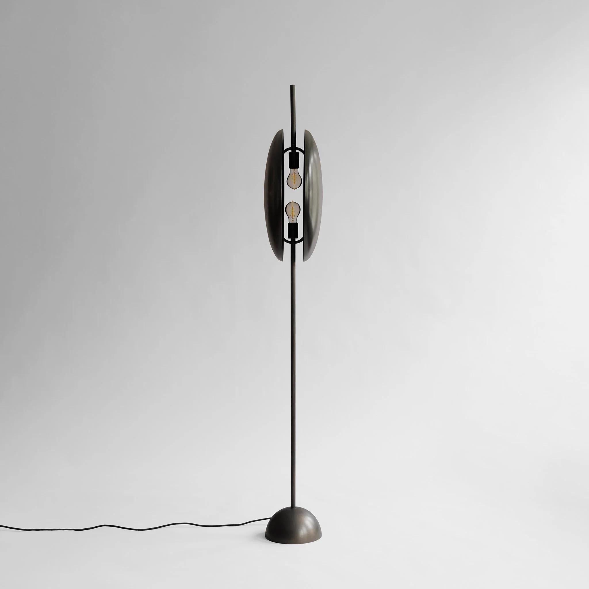 Lámpara de pie con acabado en bronce, obra contemporánea

Oculta entre dos pantallas metálicas circulares con los extremos ligeramente curvados, la fuente de luz se intensifica y se expresa en una experiencia de iluminación indirecta que cambia