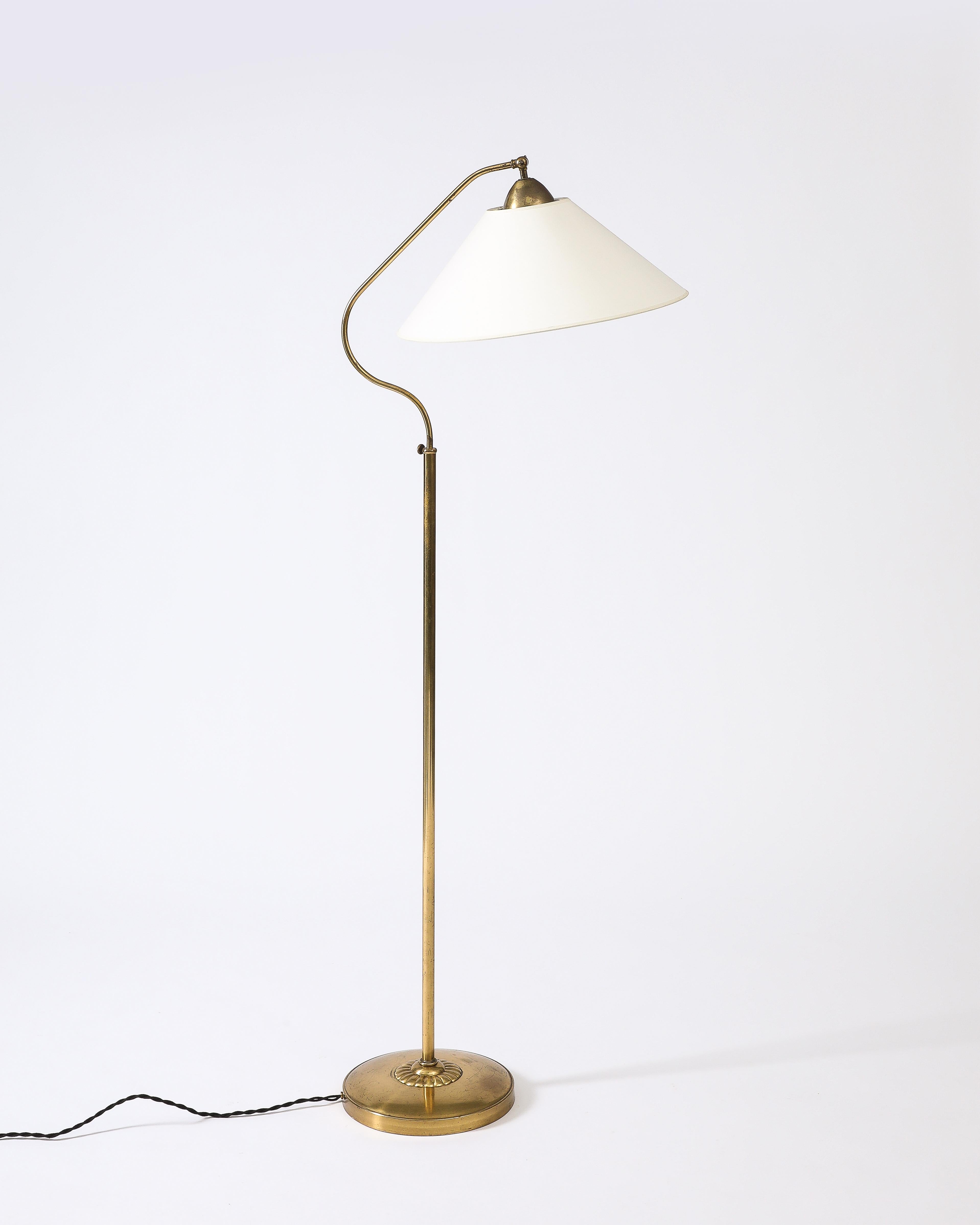 Beautiful floor lamp with adjustable height and lamp shade, with minor patina to the brass base.