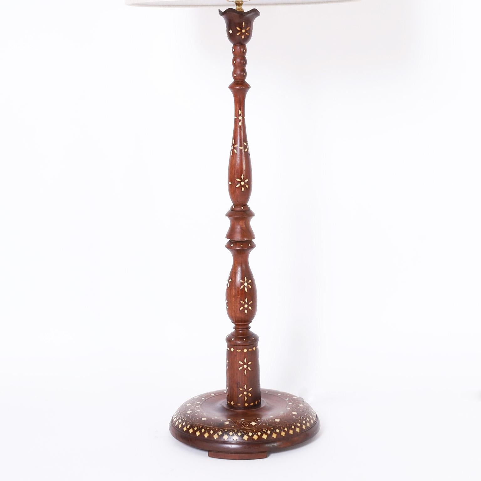 Exotic antique Anglo Indian lamp crafted in mahogany with classic turned form and decorated with floral bone inlays.
