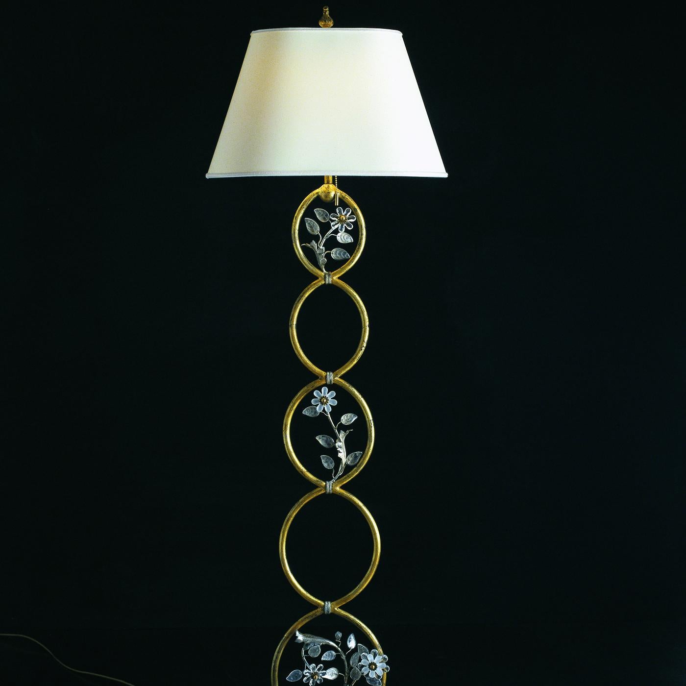 The jewel-like allure of this superb floor lamp will enrich large foyers, living rooms, or bedrooms with romantic allure while providing warm ambient illumination. Entirely fashioned of hand forged iron, five circles extend in decreasing size from a