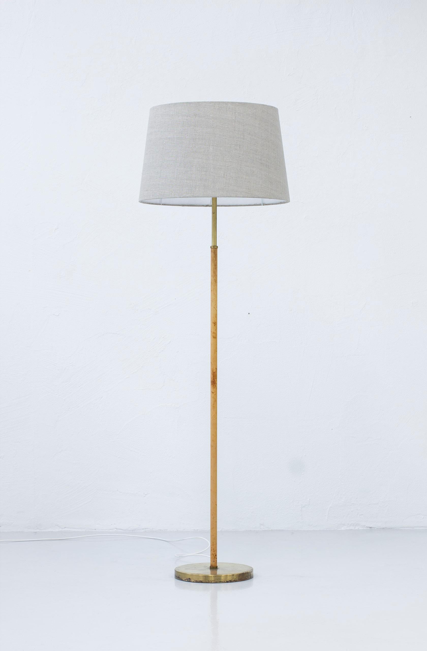 Floor lamp model 588 G designed by Anders Pehrson for Ateljé Lyktan. Produced in Sweden during the 1960s. Made from brass with original leather on the stem. Original shade with acrylic diffusers. The shade has been reupholstered in grey linen