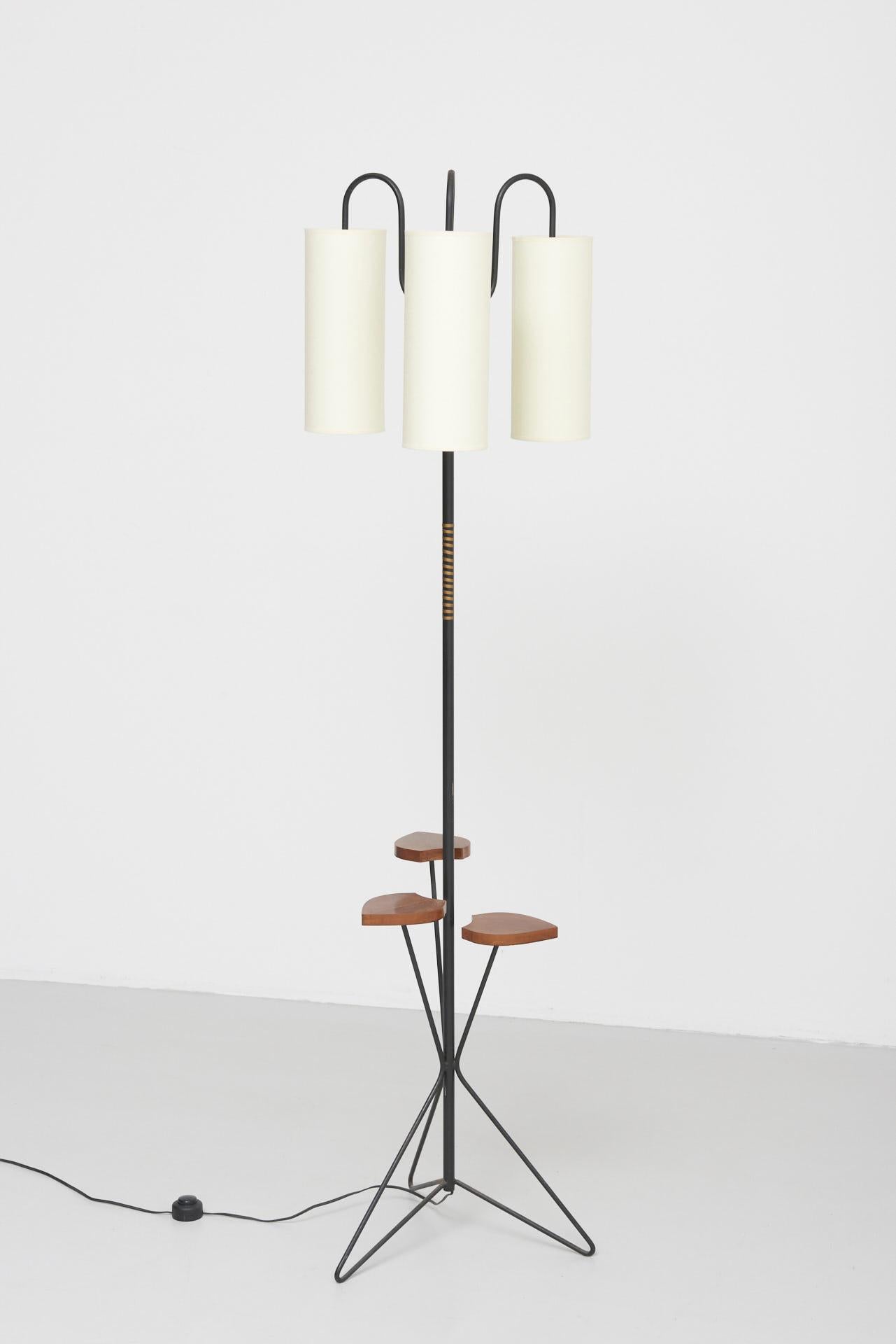 A midcentury floor lamp made in black steel with three lamp shades in linen. The three leaves in teak can be used as side table for a drink or small items. Made in France in the 1950s.