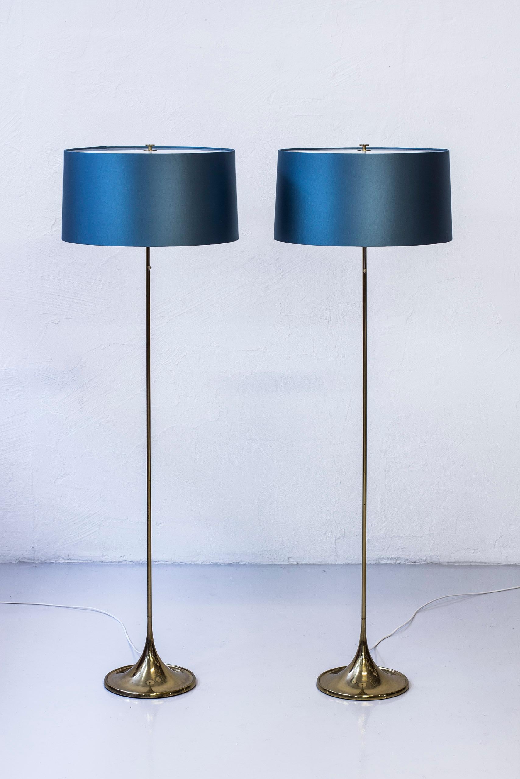 Pair of floor lamps model G-024 designed by Alf Svensson and Yngvar Sandström and their designs studio S-Design. Produced by Bergboms in Malmö, Sweden, circa 1961.  Made form polished brass with cast iron in the base. Lamp shades with acrylic top