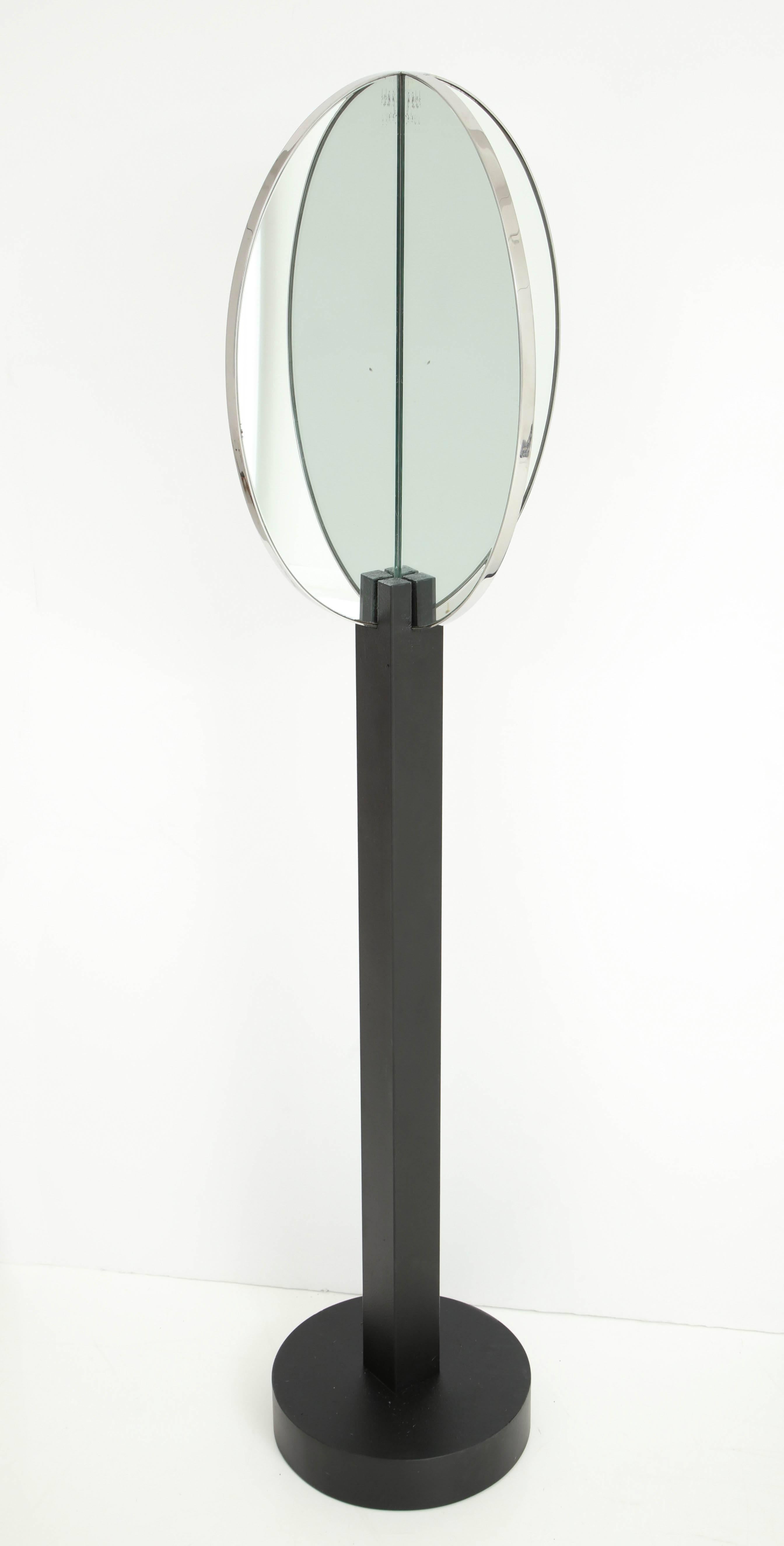 The 1980s standing floor mirror was designed by NYC Avant Garde window dresser Robert Currie for Henri Bendel's 57th street store.
The Minimalist stand supports a three part mirror divided into two quarter sections and one halve section.
 