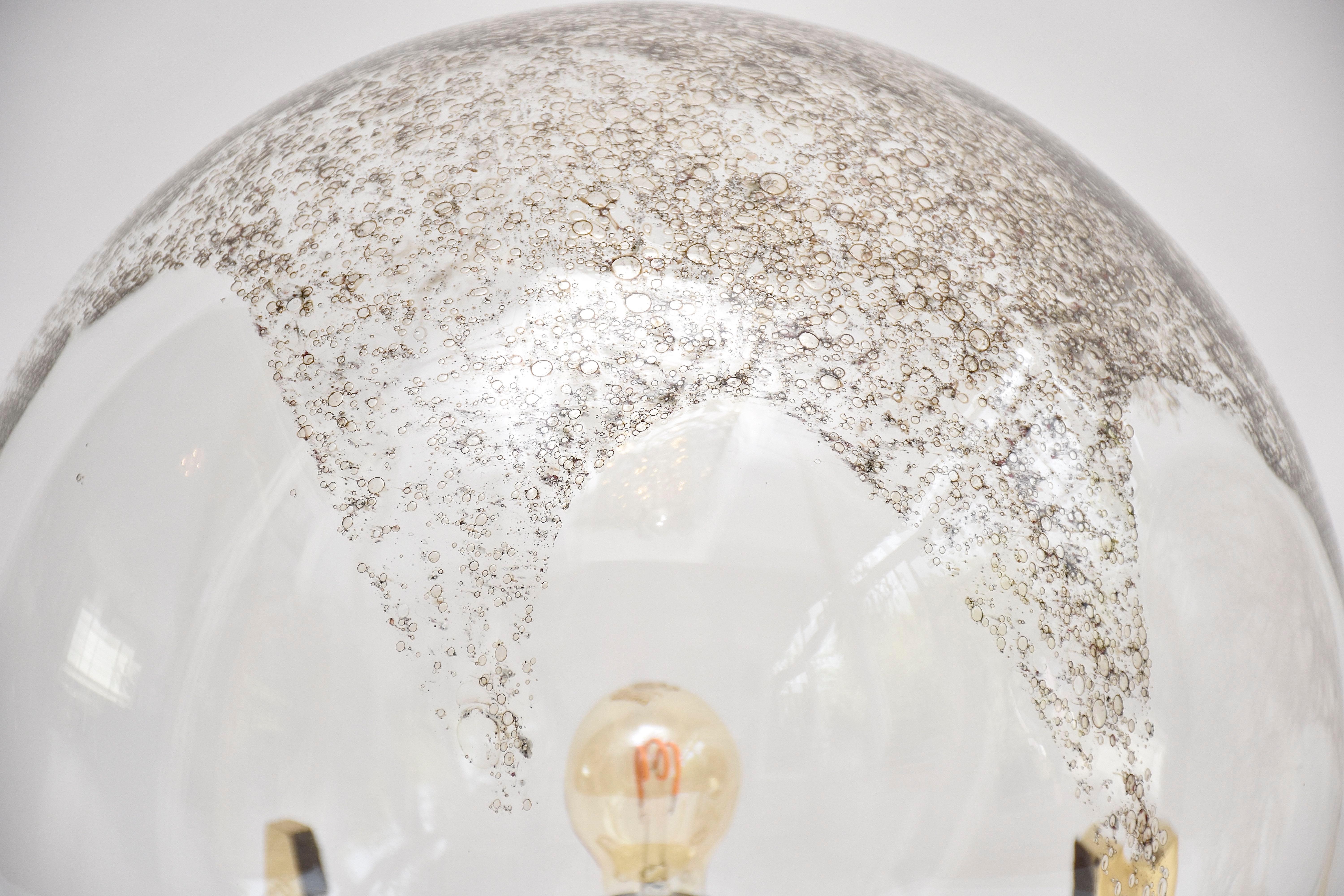 Eine sehr dekorative und zeitgenössische Steh- oder Tischleuchte von La murrina Murano.
Geblasene Glaskugel mit Eisenoxid im Inneren, was der Lampe ein spektakuläres Aussehen verleiht.
Rahmen aus poliertem Messing. 
Herkunftsort - Italien
Zeitraum-