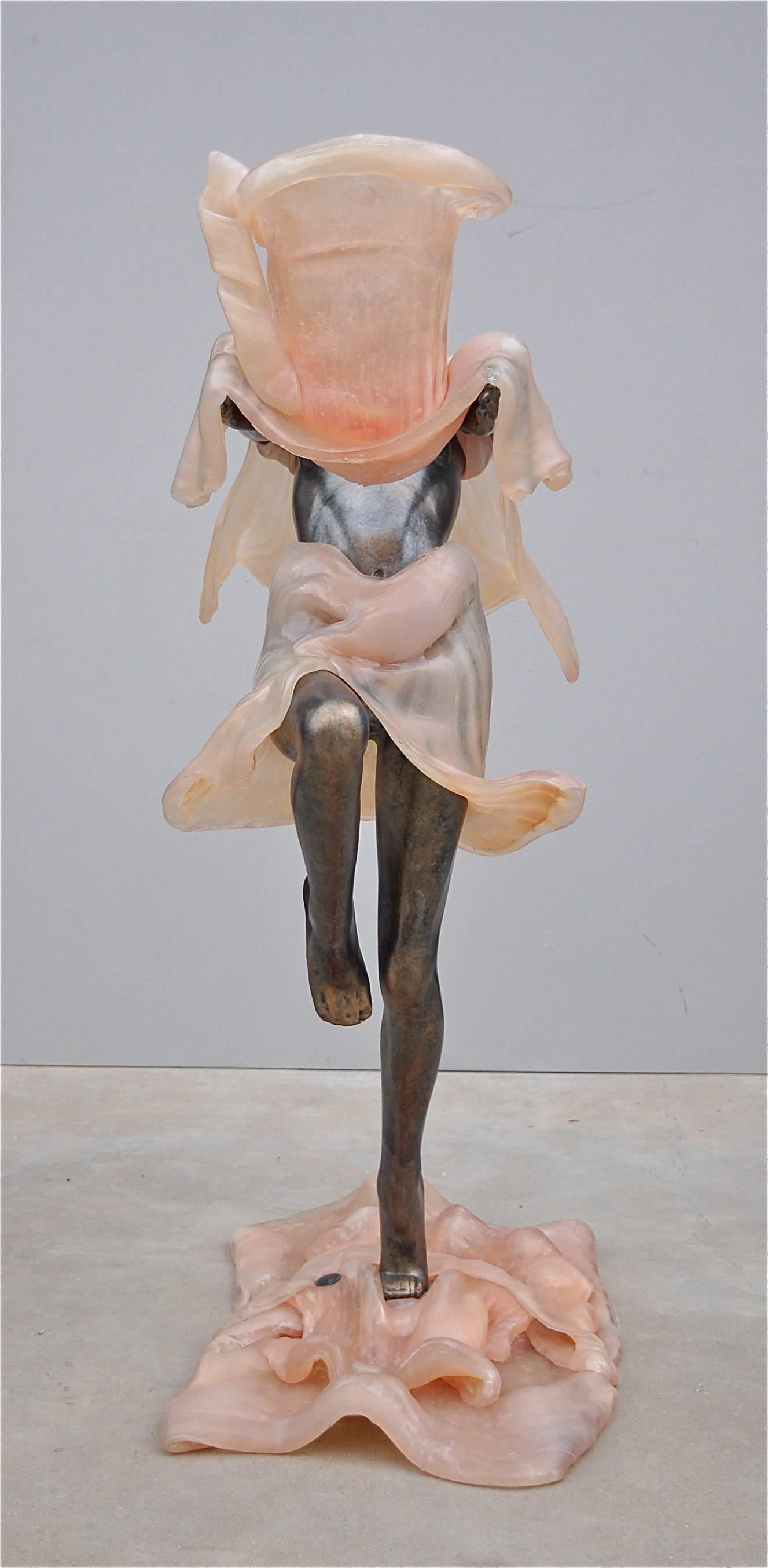 D'une hauteur de 116 cm (45,6 pouces), cette pièce accrocheuse de l'artiste Remo Pintus (1938-2002) allie art et fonction. En utilisant une résine résistante, l'artiste a capturé le mouvement dynamique et fluide de cette danseuse à moitié nue en