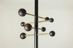 Floor-to-ceiling coat rack in lacquered metal and brass. Contemporary.