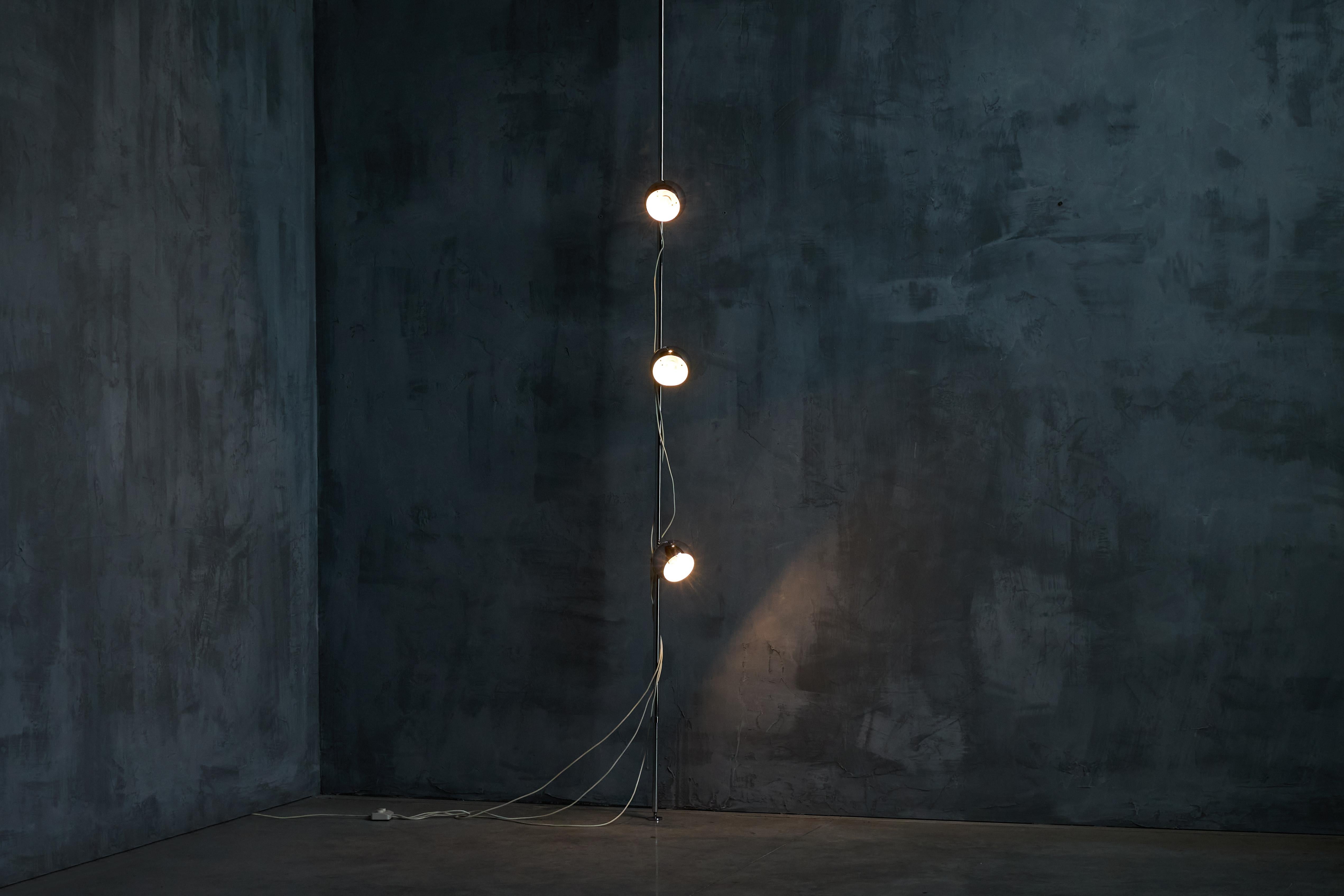 Questa lampada da terra di design italiano di Goffredo Reggiani degli anni '70 è caratterizzata da un'estetica elegante e moderna. L'altezza regolabile gli permette di inserirsi perfettamente tra il pavimento e il soffitto, adattandosi a varie