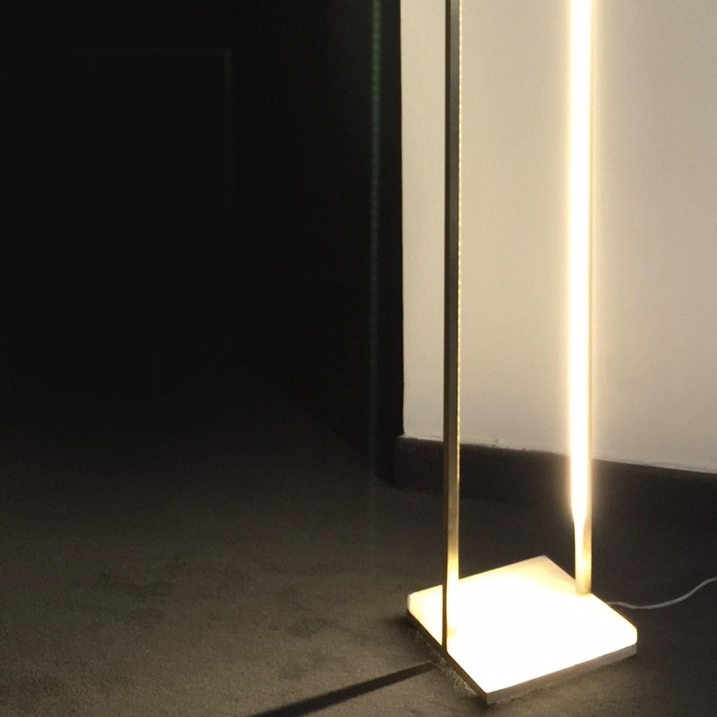 This exquisite lamp features a structure in brass that creates an elongated rectangular shape that will give a touch of modern sophistication to any decor. The LED lights, which run throughout the structure and can be dimmed, will create unique