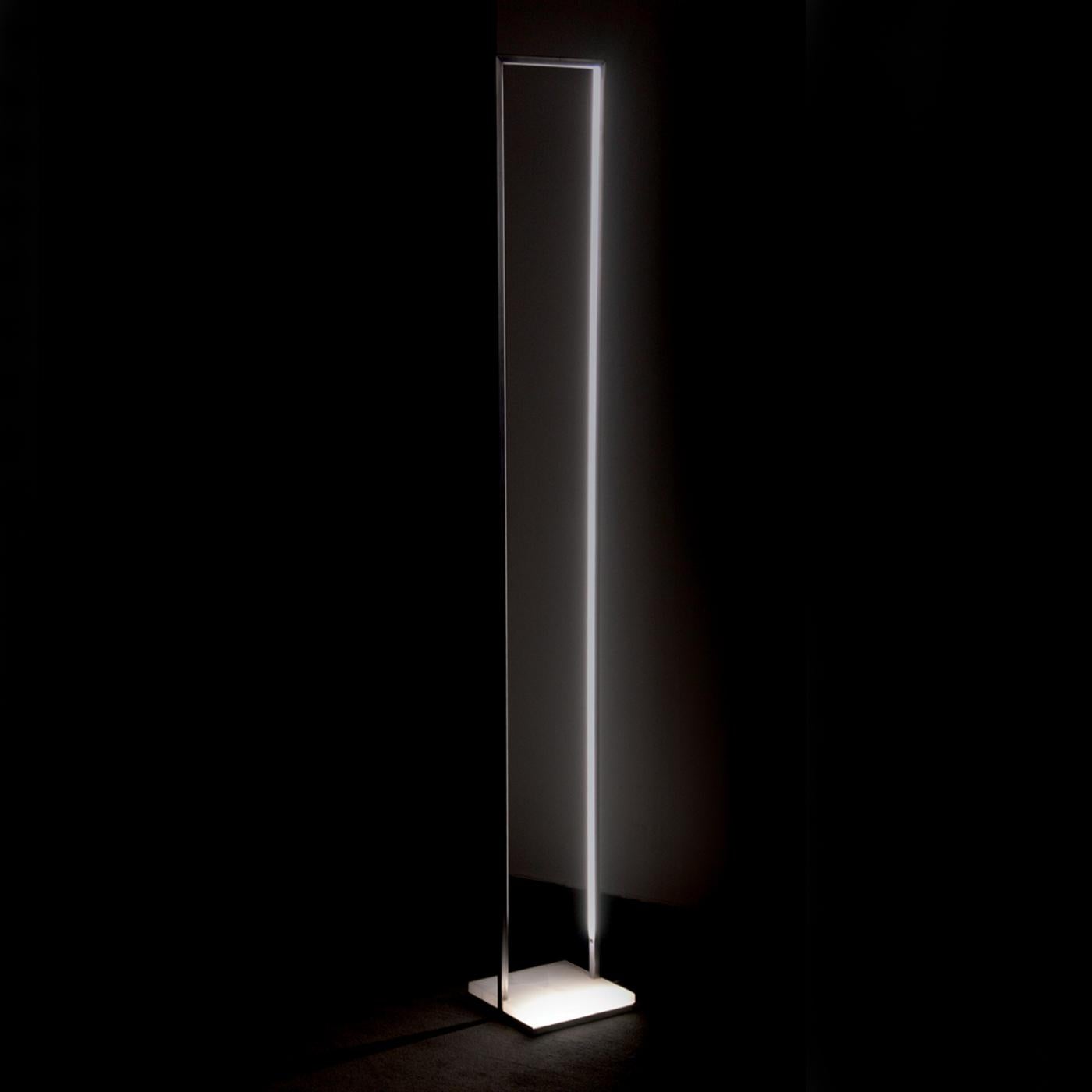 Striking and modern, this exquisite lamp rests on a square of white onyx stone and its structure, entirely made in iron bars with a square section, forms an elegantly elongated rectangle that evokes the shape of a tall and narrow window. On the