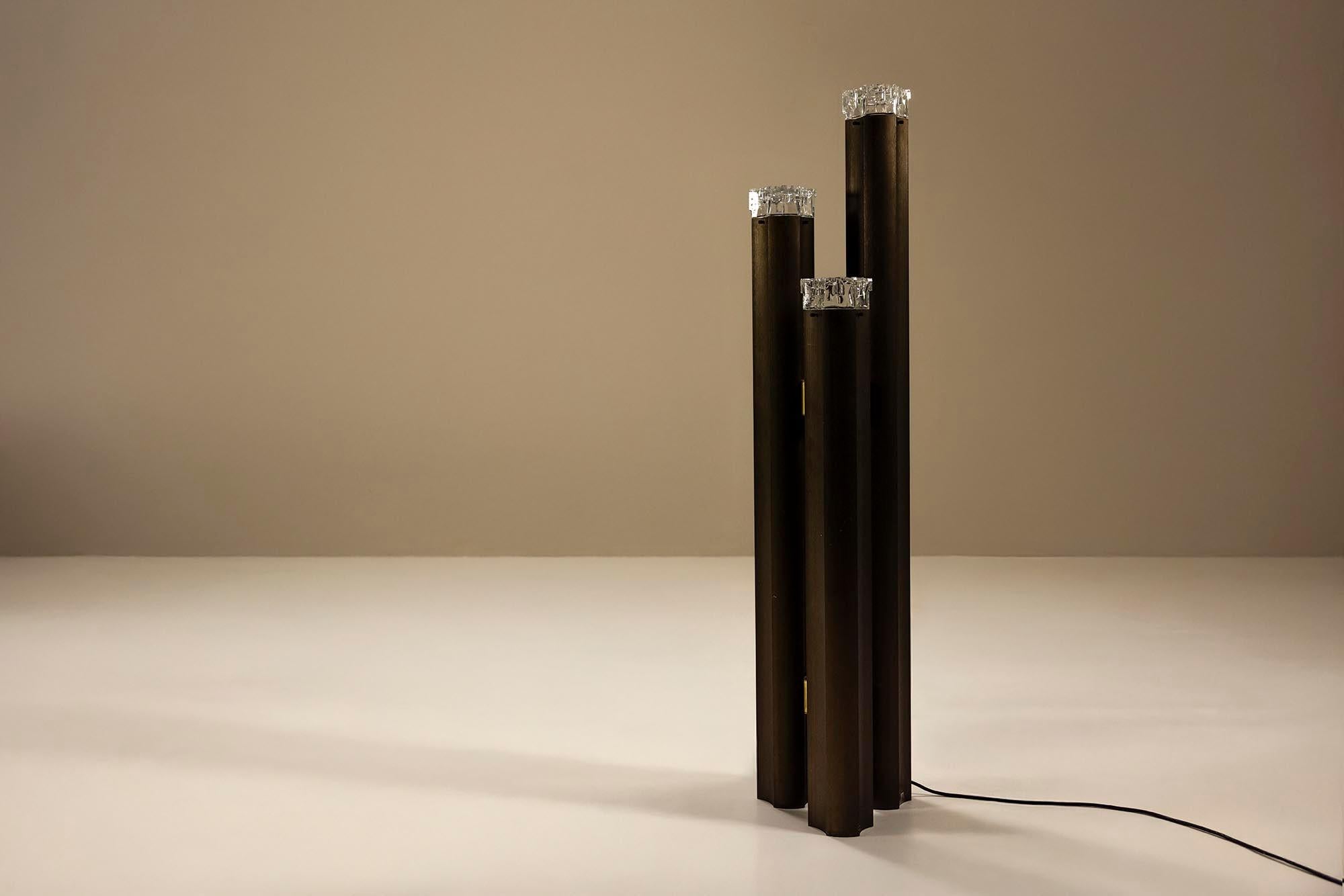 Questa lampada da terra scultorea è un pezzo notevole degli anni '70, disegnato da Gaetano Sciolari. Conosciuto per la fusione di estetica brutalista e materiali glamour, il lavoro di Sciolari ha ridefinito l'illuminazione nell'Italia del