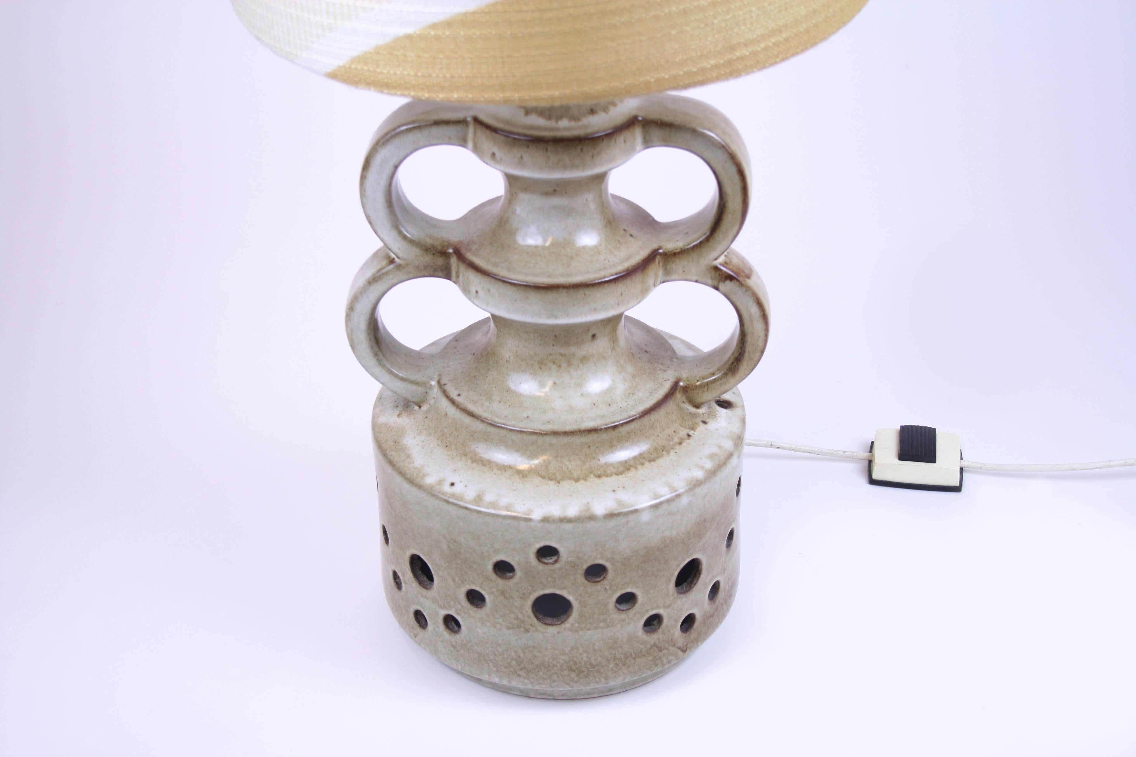 Lampadaire à base de poterie en céramique partiellement évidée, France années 1960. Objet très inhabituel à caractère sculptural en parfait état d'origine et non restauré. L'abat-jour présente des motifs typiques de l'époque.