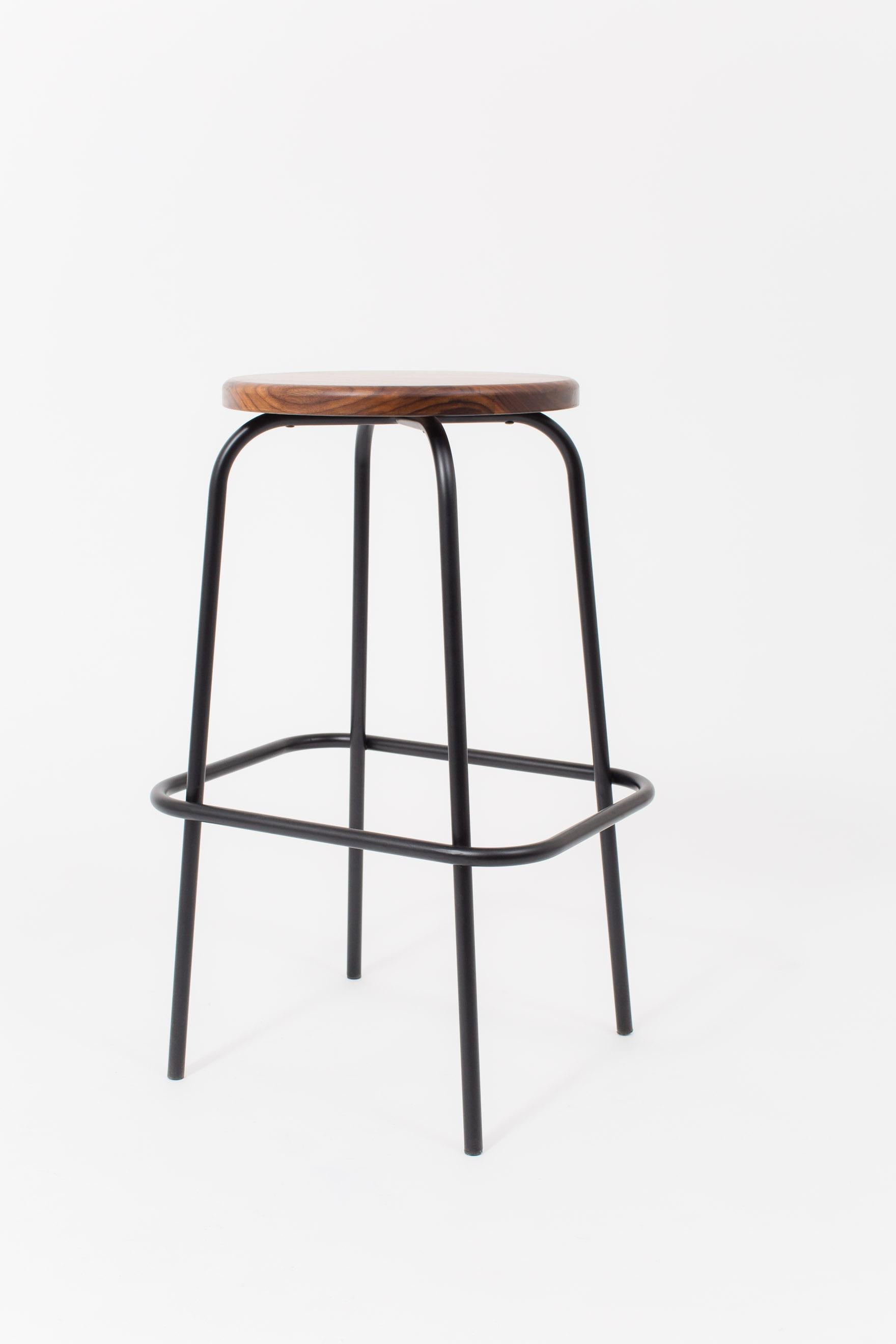 These walnut-seated stools with tubular steel base were designed for Flora coffee at the Met Breuer. Gently curving legs encircled by a continuous rail offers a place to rest your feet. Natural walnut and matte powder-coated steel. Hand rubbed 0%