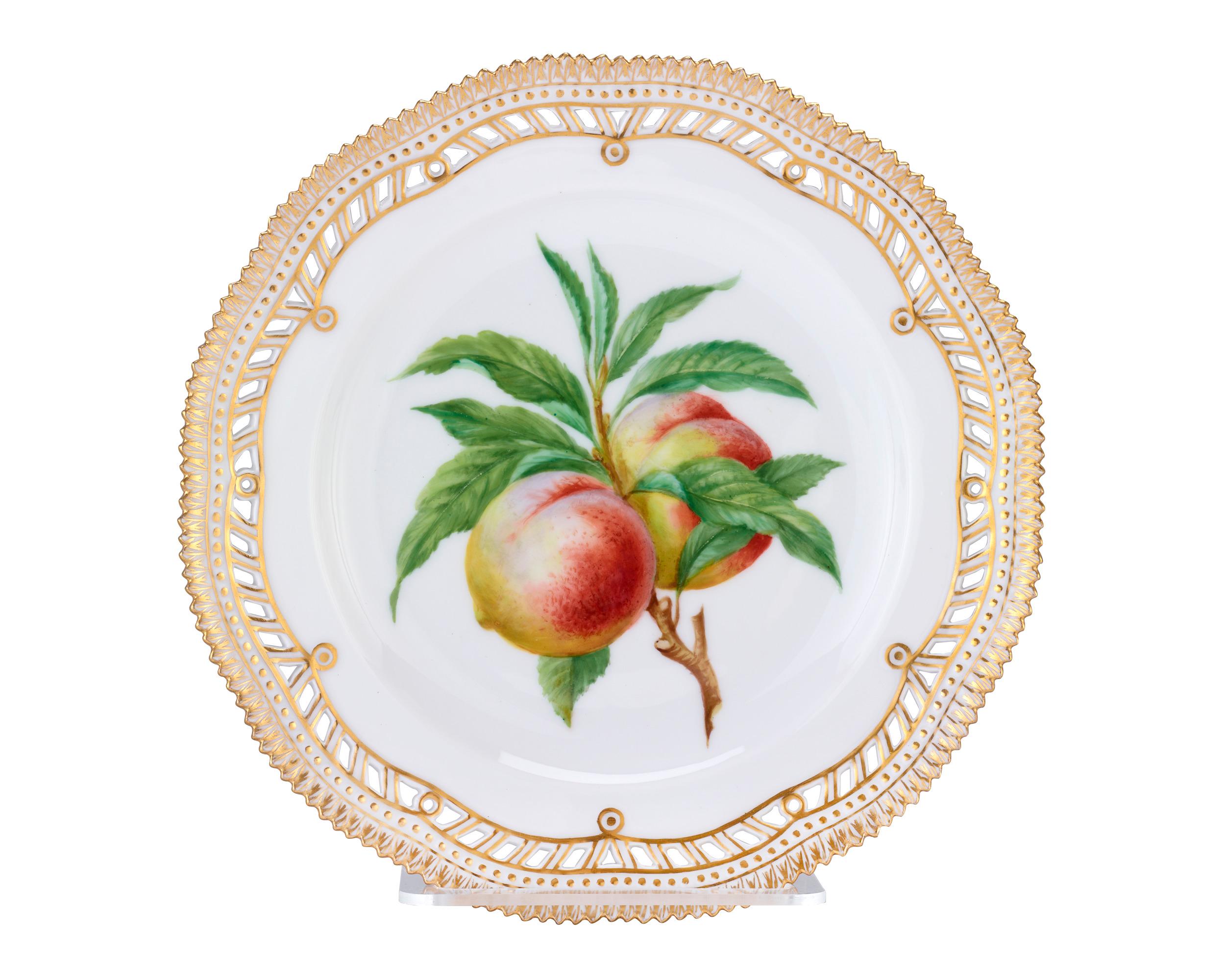 Vibrant, hand painted fruits adorn these rare Flora Danica dessert plates by Royal Copenhagen of Denmark. While most Flora Danica features the native flowers of Denmark, this set of 12 plates is set apart by its colorful fruit motifs, which include