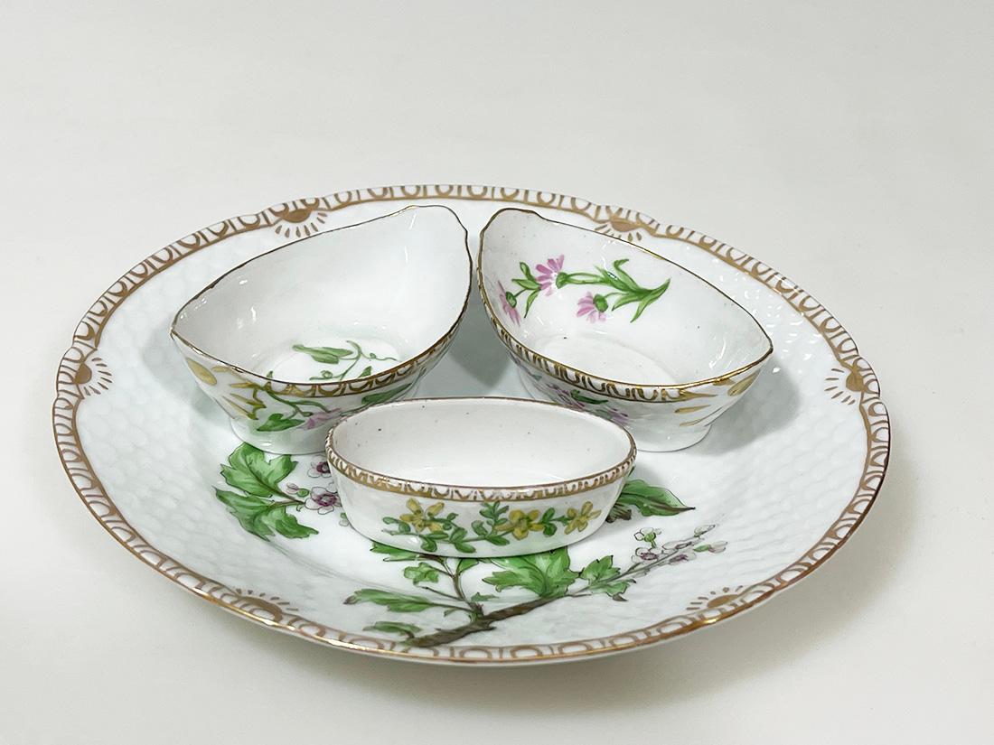 Flora Danica Porzellanset von Bing & Grøndahl, Dänemark 1928-1931

Porzellanset von Bing & Grøndahl, handbemalt von Frida Meyer (Gluud) 
Ein Porzellanteller aus dem Jahr 1931, 2 Salzstreuer aus dem Jahr 1931 (einer nicht datiert) und ein kleiner