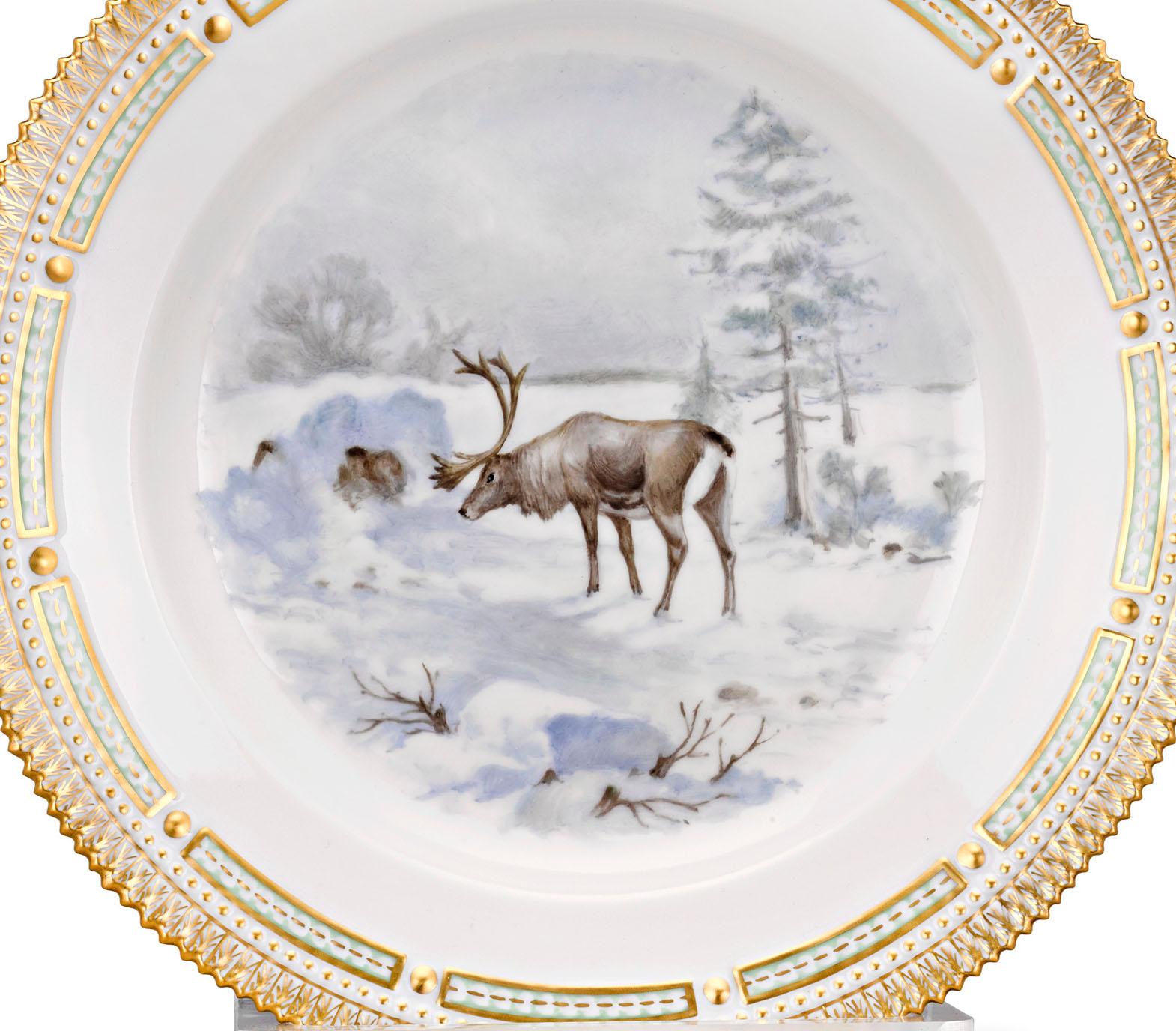 A reindeer is the star of the snowy scene on this extraordinarily rare porcelain dinner plate. Crafted by Royal Copenhagen, it is part of the firm's highly celebrated Flora Danica collection. Flora Danica is known worldwide for its intricate and