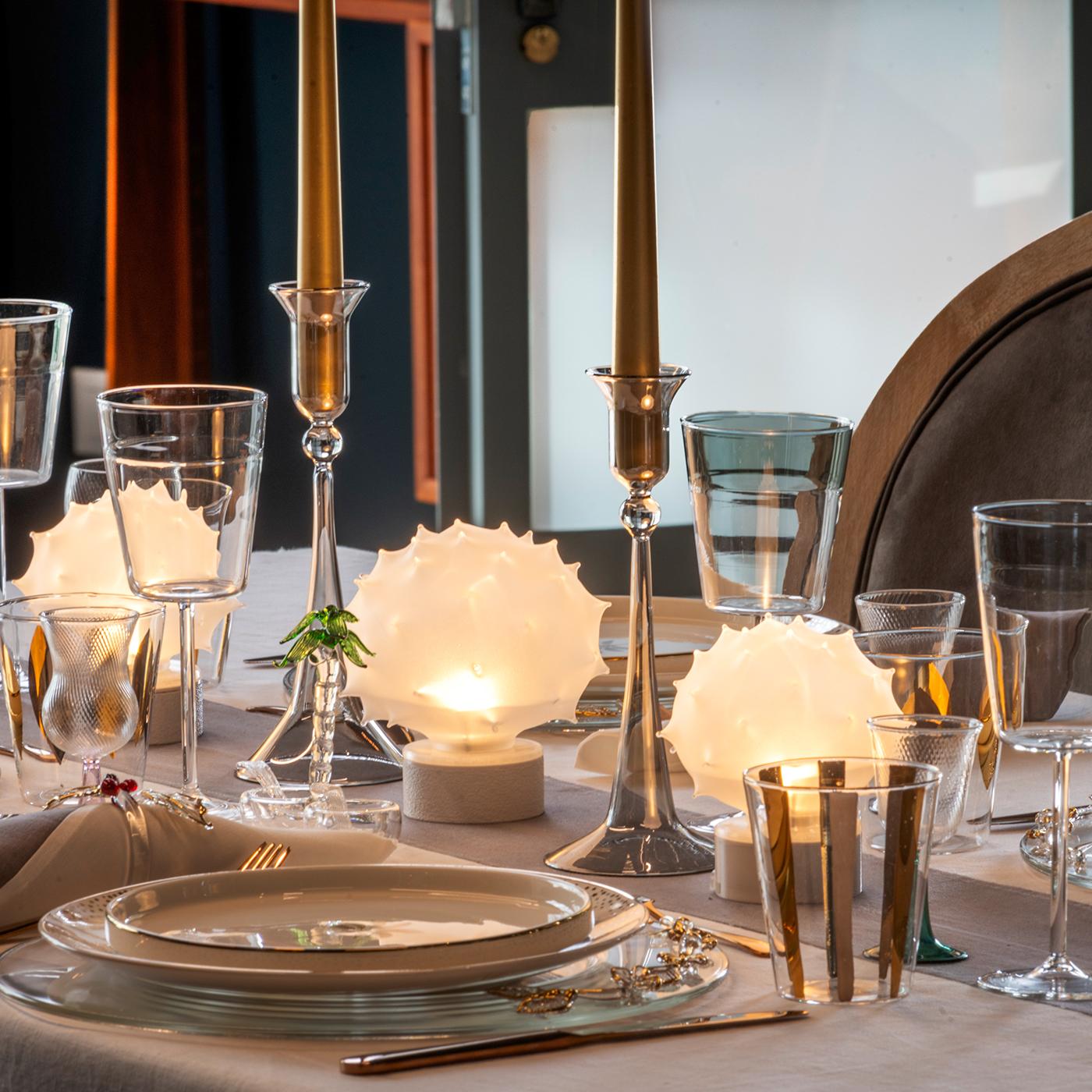 Il sottopiatto Flora Gold è un piatto in vetro trasparente realizzato a mano con foglie e fiori in oro 24 carati applicati a mano. Disegnato da Catherine Urban, questo elegante pezzo mette in mostra l'artigianato veneziano con 20 elementi in vetro