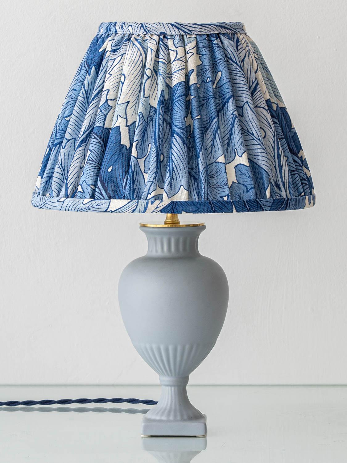 This vintage ceramic table lamp was handcrafted by Amitābha Studio in Amsterdam from a rare amphora-shaped vase by Flora Gouda, part of the Porcelina series produced between 1950 and 1970. We’ve paired the base with a bespoke hand-pleated lampshade