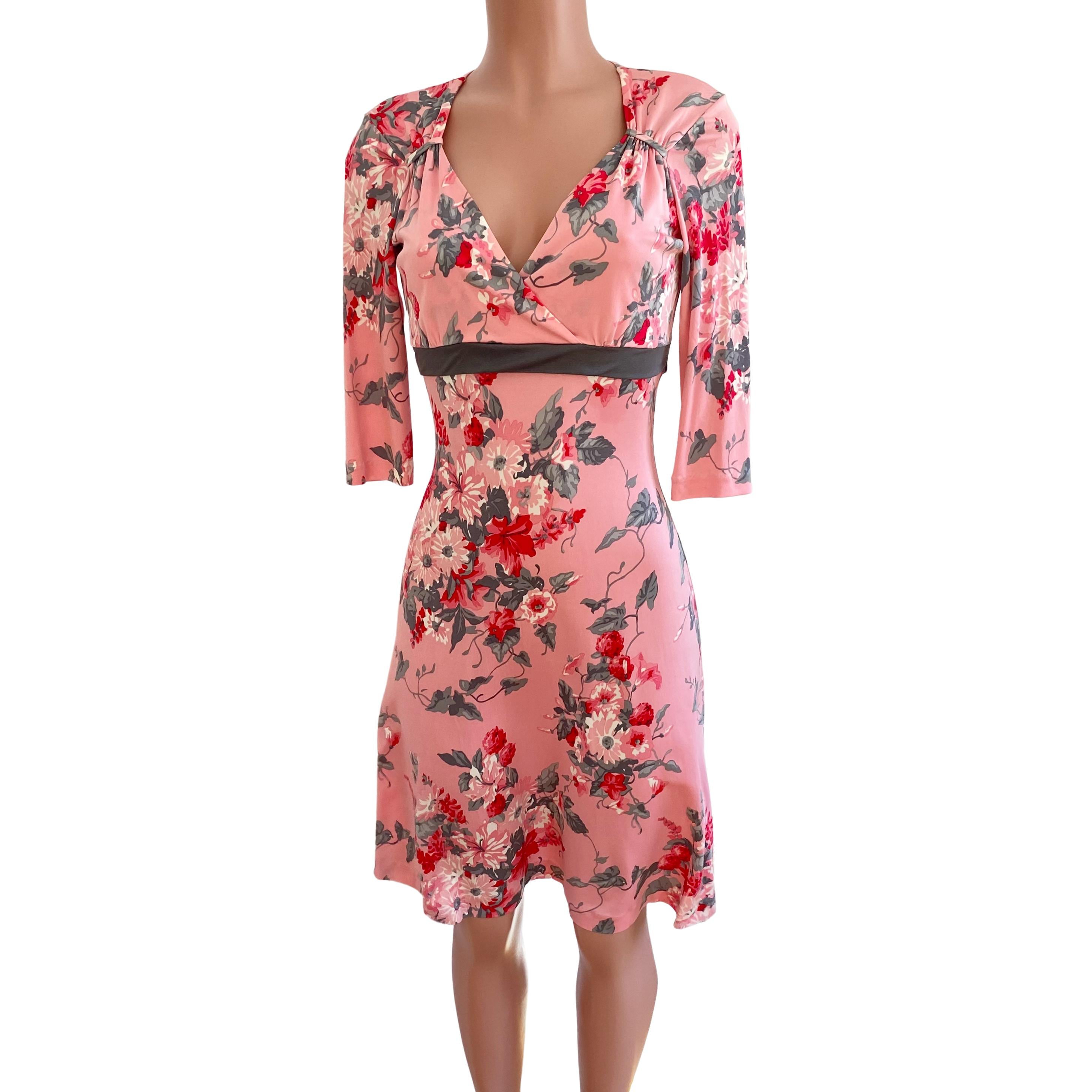 Pretty pink mock wrap dress with flared skirt and ties at back.
3/4 sleeves.
Approximately 41