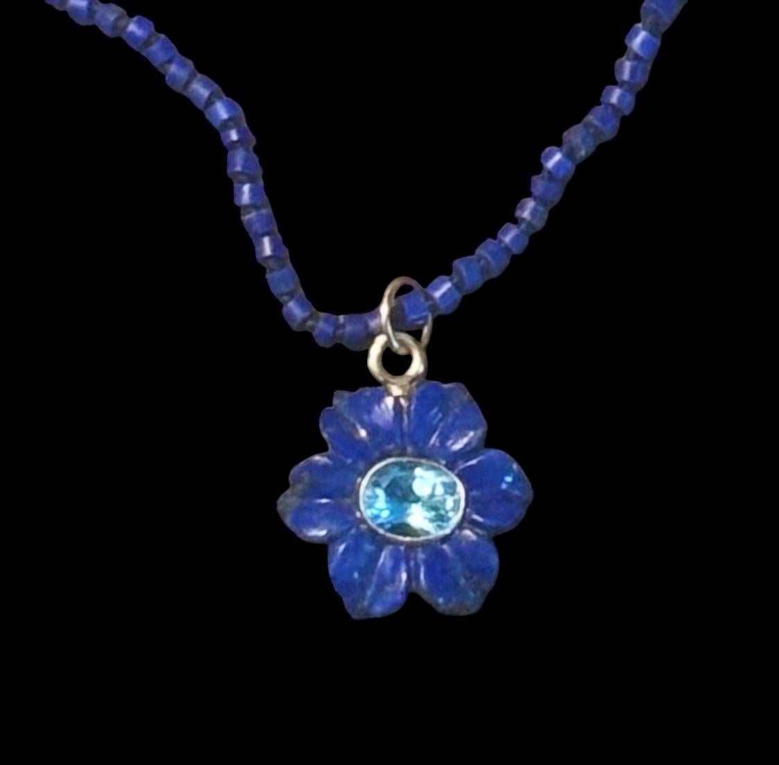 FLORA Necklace
Lapis Lazuli, Blue Topaz and 14k Gold

The pendant is a carved lapis flower that measures 25mm in diameter. The gorgeous center blue topaz is a 9x7mm oval blue topaz and is bezeled in 14k gold. 

The pendant comes on a beautiful lapis