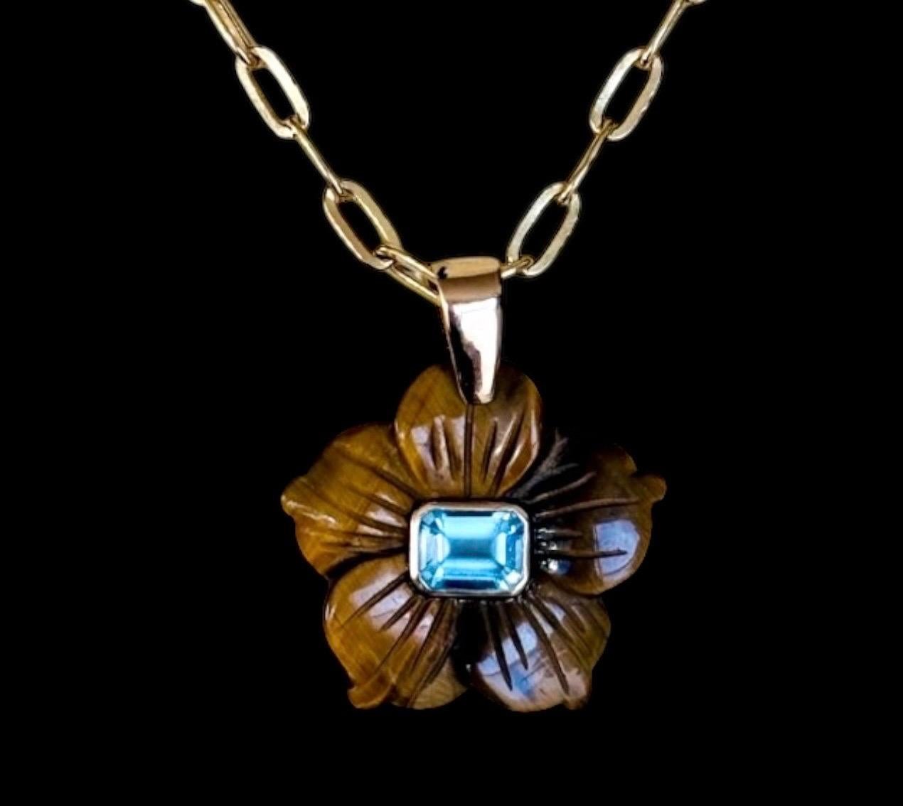 Ciondolo FLORA

Occhio di tigre, topazio blu, oro 14k

Fiore intagliato di occhio di tigre (1,25