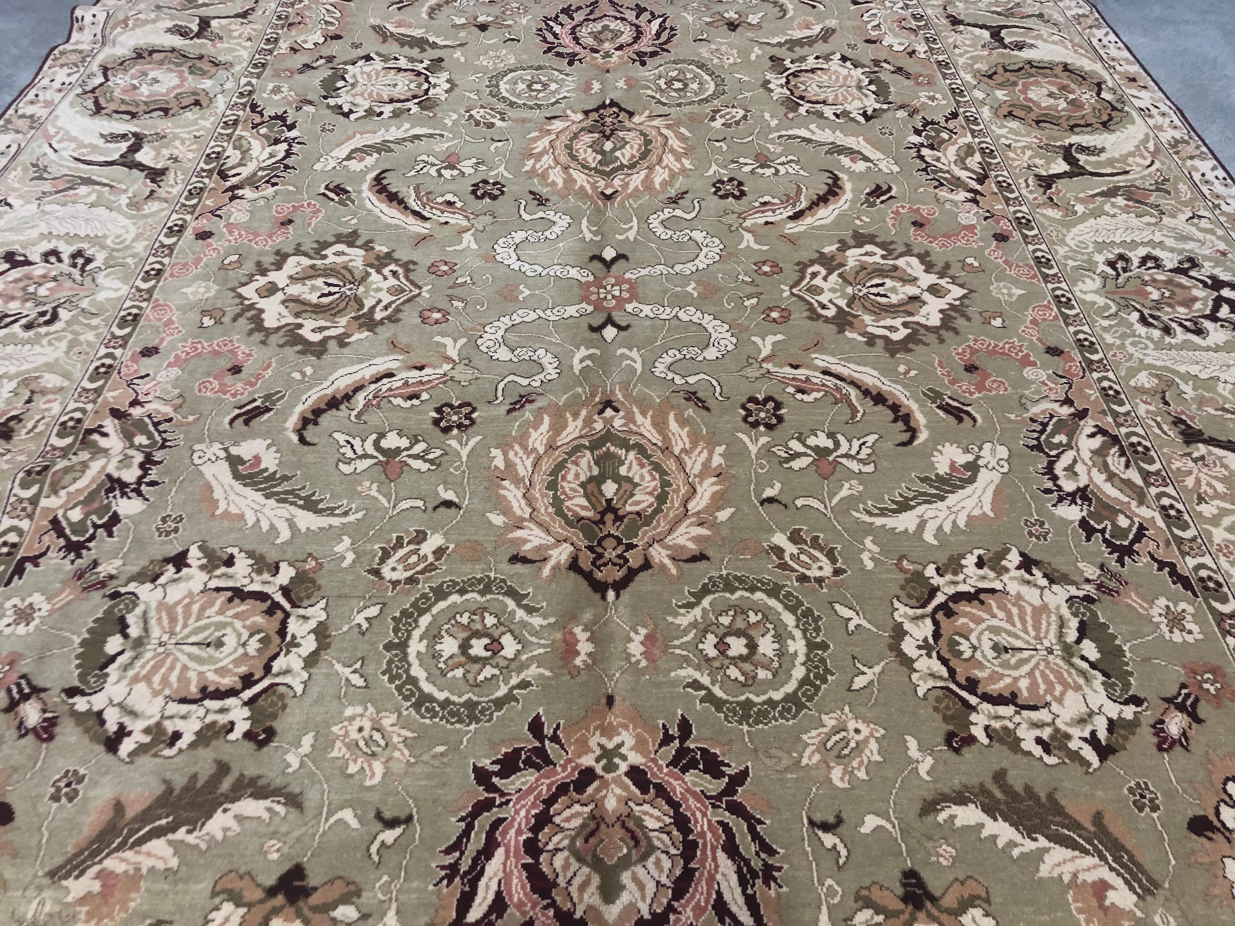 A dazzling floral motif in red, coral, cream and olive tones swirls across a beige background in this stunning Agra style Egyptian area rug. Floral ribbons define and frame the space in which feather-light flowers and leaves swirl. The Agra style at