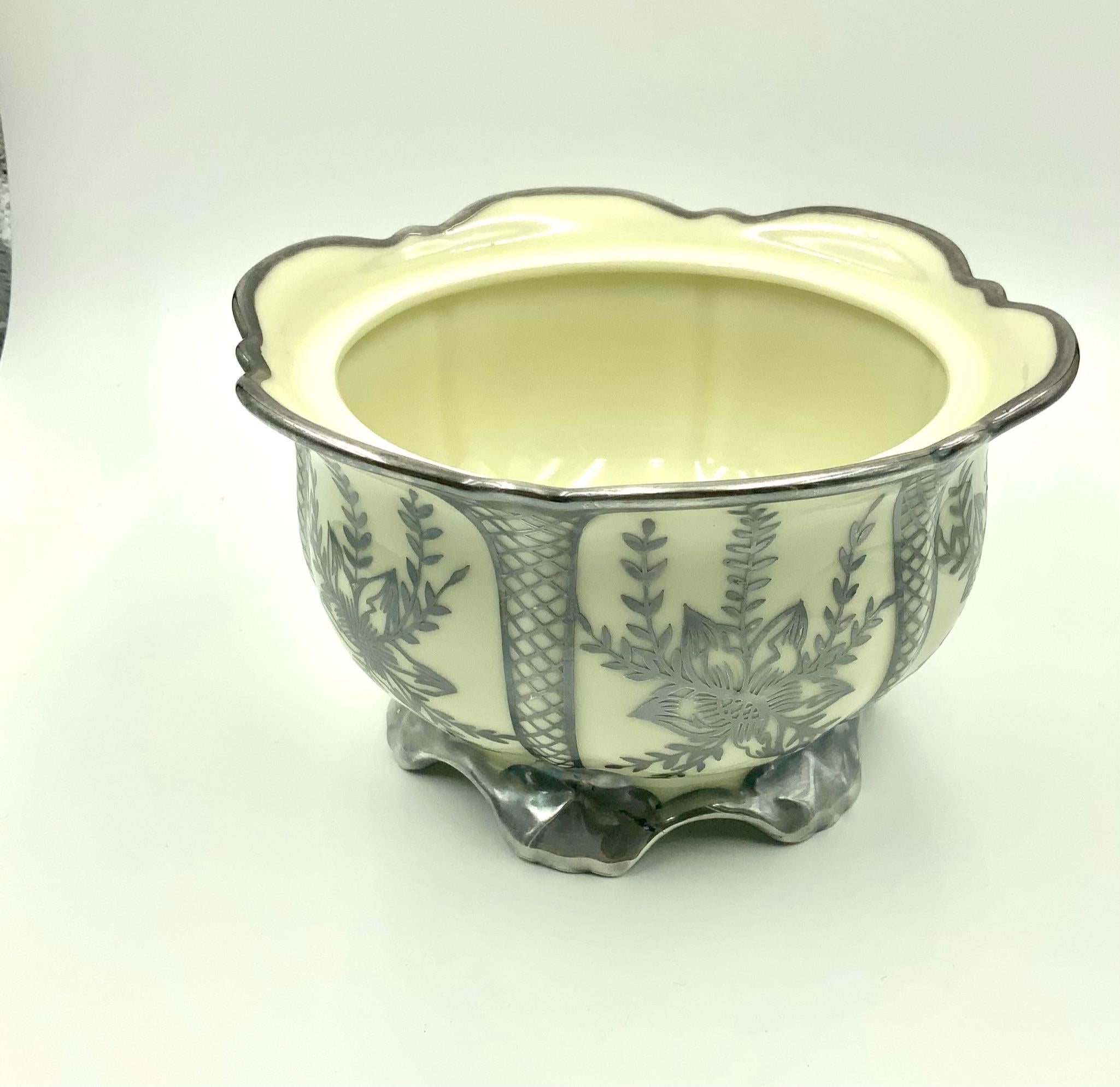 Early 20th century off white porcelain covered bowl by Schoenau Germany featuring a sterling silver overlay design with flowers sections separated by six basket weave sections. The top has a silver overlay finial and the bottom has six silver