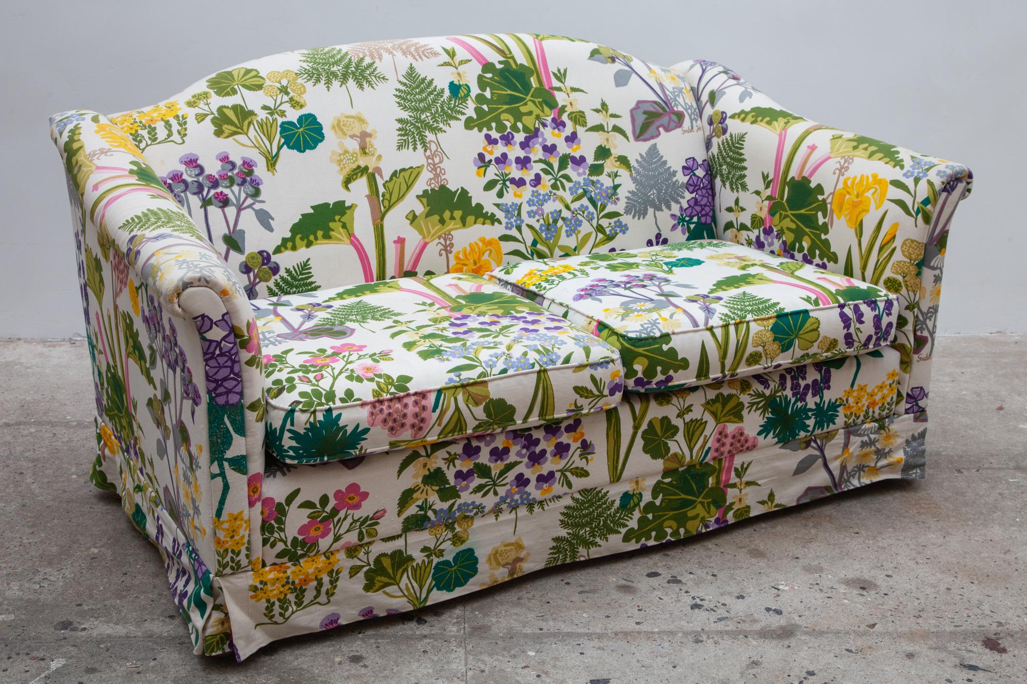 Vintage floral print couch. The fabric is designed by Gocken Jobs, 1969 and features pansies, ferns,rhubarb and more in the botanic garden print.
Gocken Jobs (1914-1995) was a Swedish ceramisist and textile designer. While her sister Lisskulla Jobs