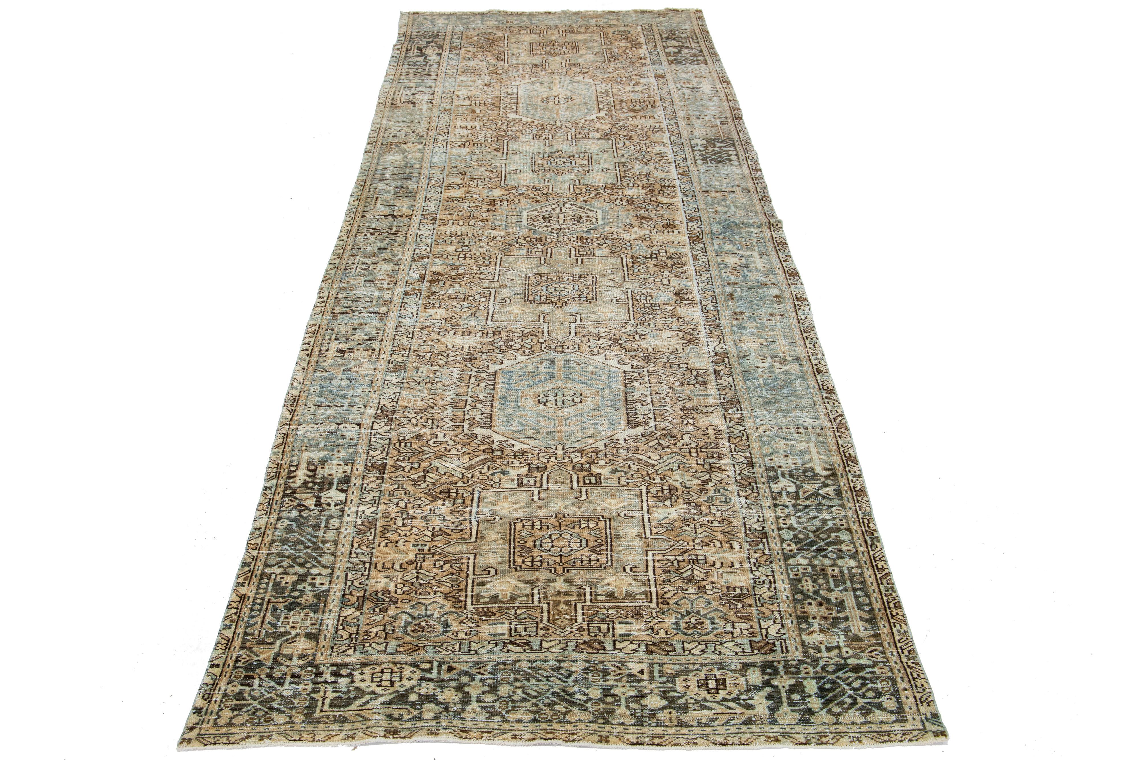 Beautiful 20th-century Heriz hand-knotted wool runner with a brown color field. This Piece has blue accents in a gorgeous tribal design.

This rug measures 4'8