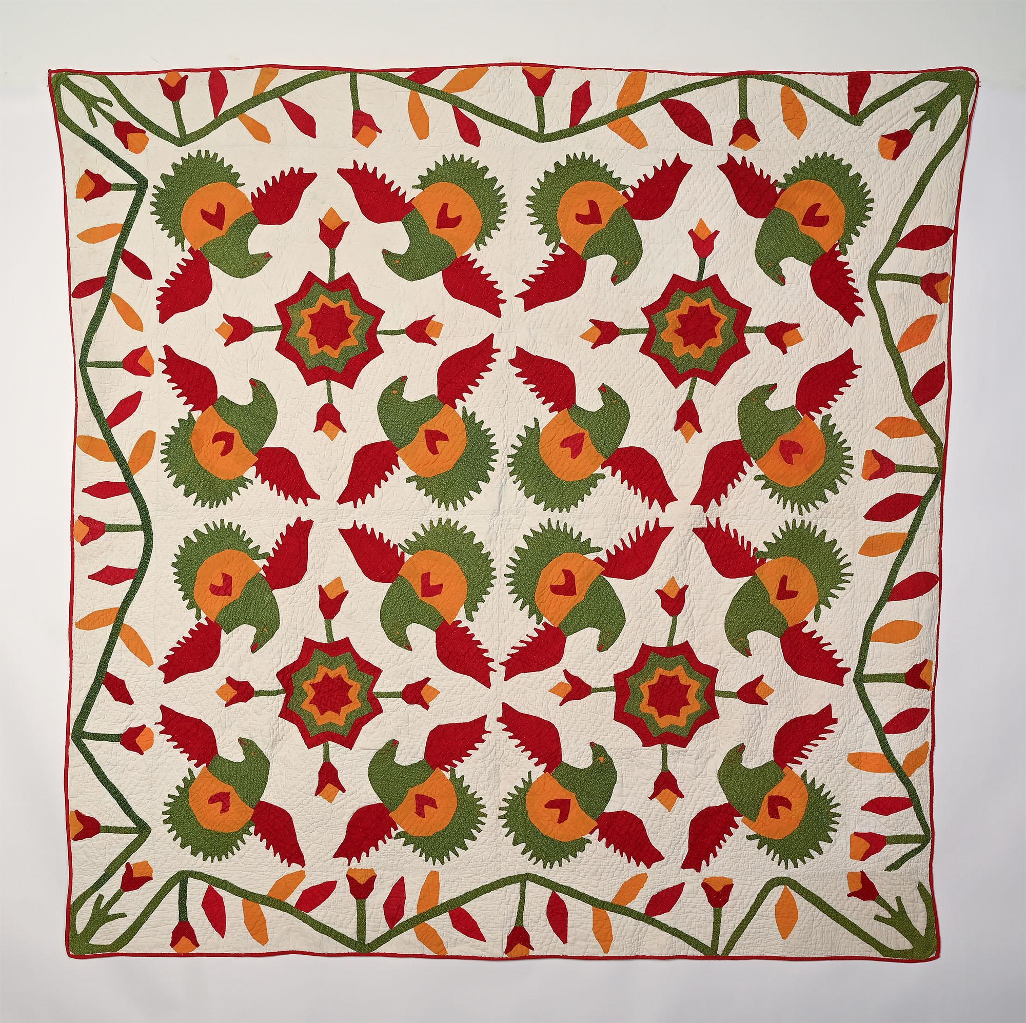 Groups of four eagles soar around a central floral block in this unique quilt. Placement of the eagles creates a scalloped white frame within the red spread wings. The orange body of each eagle has an applique that is probably meant as a heart. Each