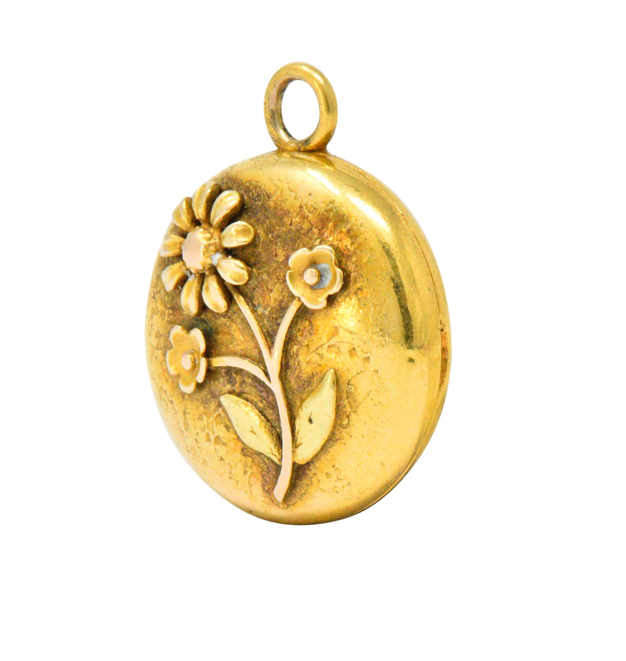 Sweet yellow gold round locket

With an applied yellow, rose and green gold flower

Engraved bird and foliate motif on verso

Opens to reveal a small frame

Tested as 14 karat gold

Diameter: 5/8 Inch

Length: 3/4 Inch

Total Weight: 3.9