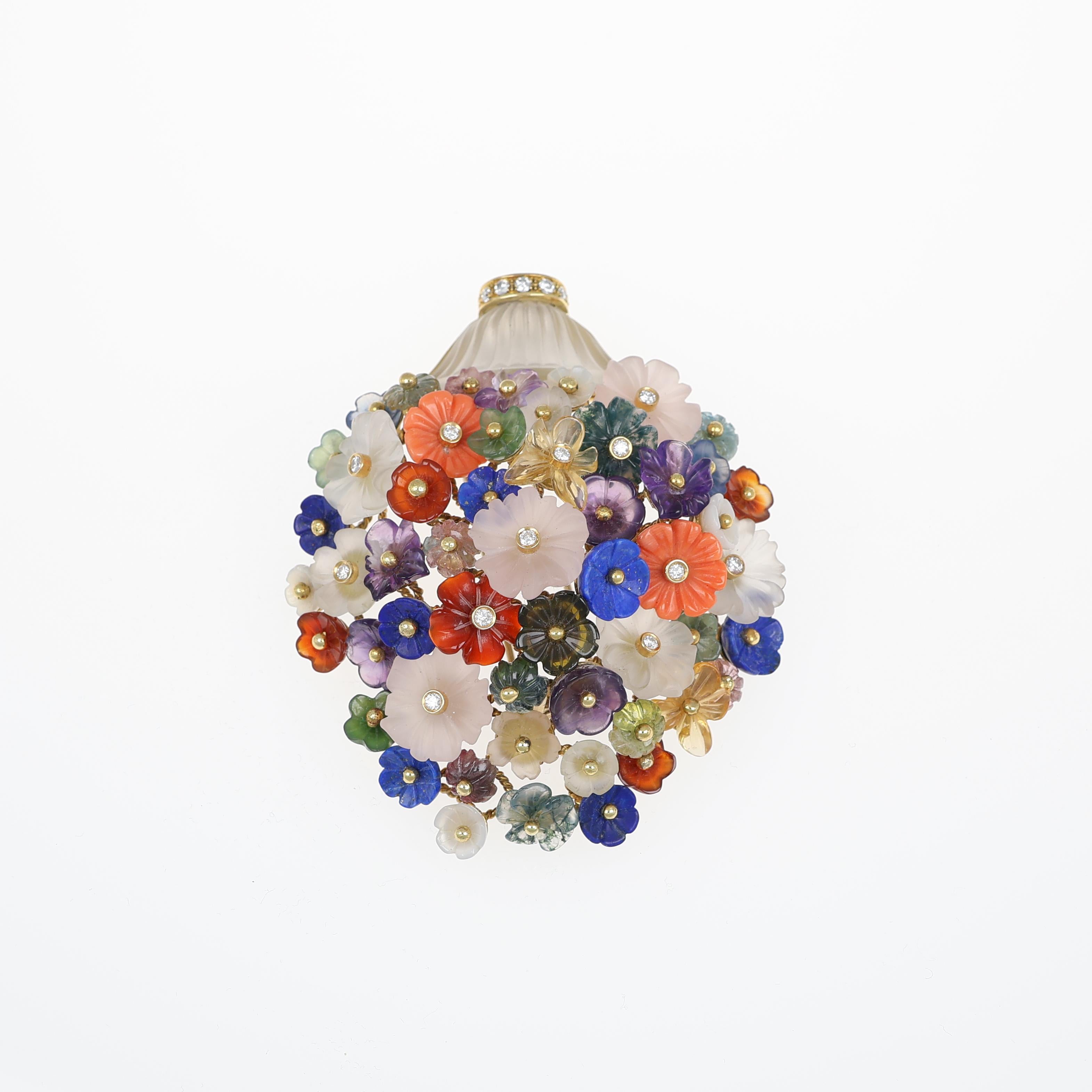 An exquisite floral brooch crafted in 18kt yellow gold, featuring a stunning bouquet of hand-carved hardstones in vibrant hues. The delicately sculpted flowers are set with brilliant-cut natural diamonds, adding a touch of elegance and luminosity. A