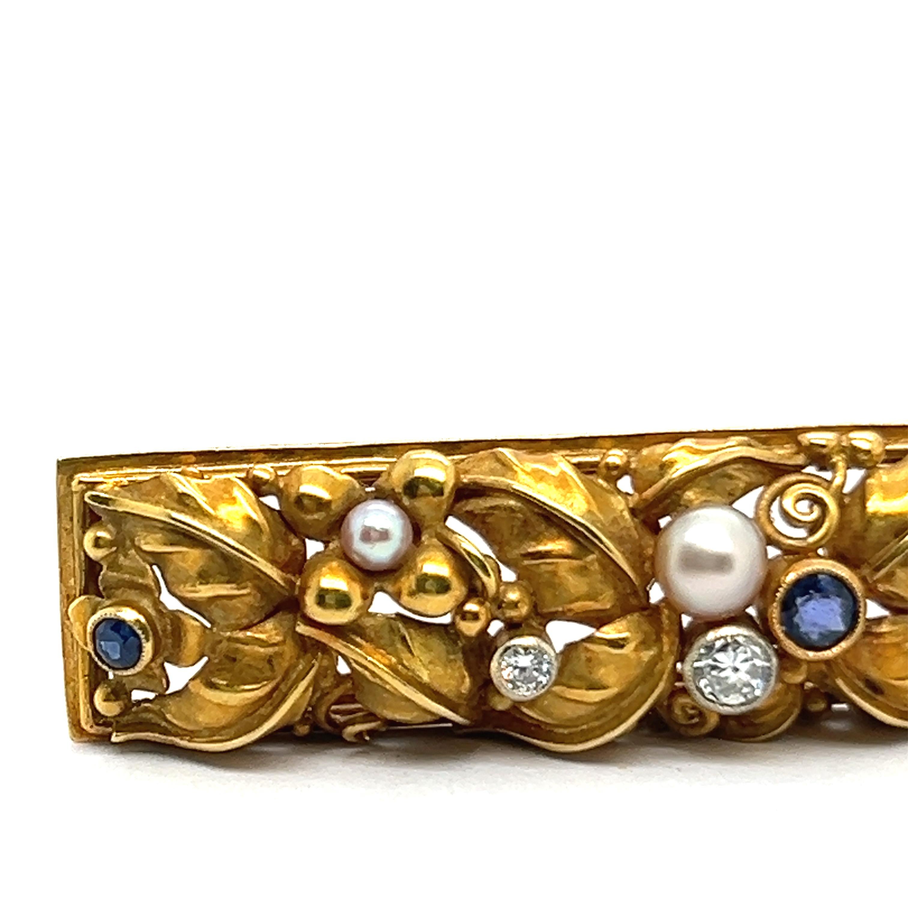 Déjate seducir por la elegancia con este exquisito broche de oro amarillo de 18 quilates, delicadamente elaborado con un cautivador motivo floral. 

Brilla con tres fascinantes zafiros talla redonda que suman 0,30 quilates y tres diamantes talla