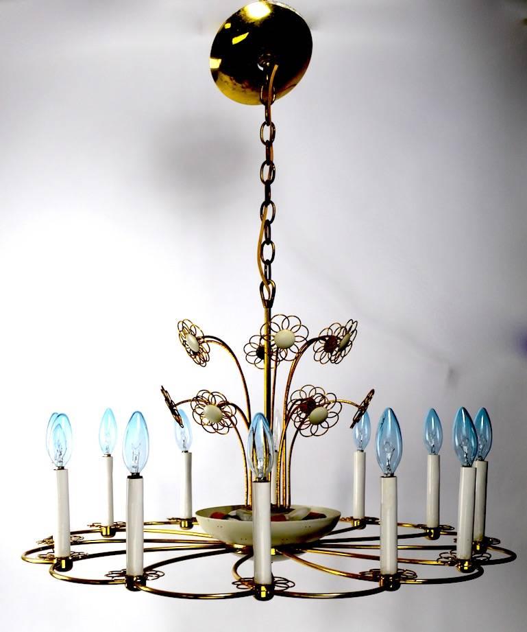 Stylish and chic floral motif chandelier manufactured by Lightolier, after Tynell. 12 exterior candle lights and four interior lights, which can be switched on/off independently to adjust generated light. White enamel paint over brass, with brass