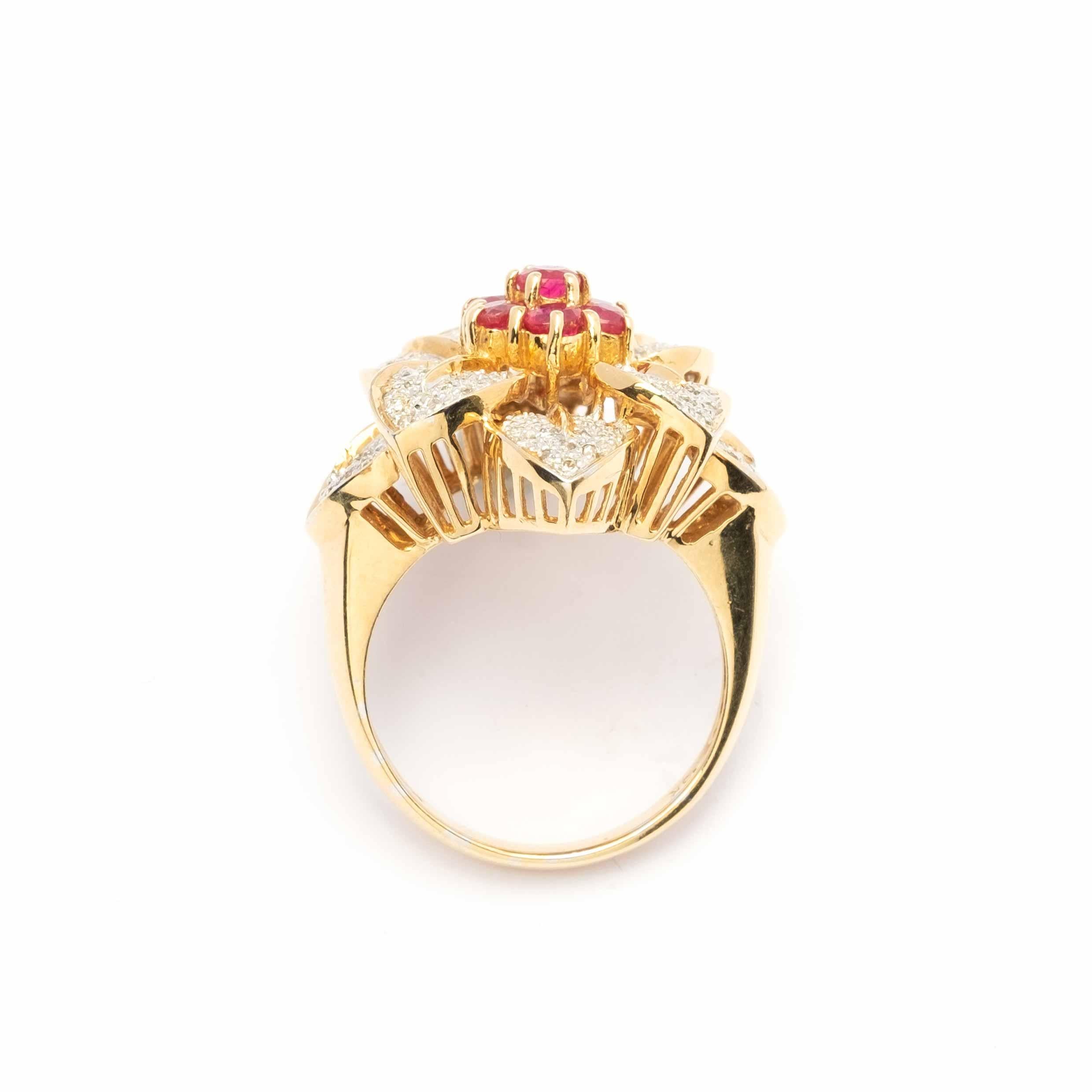 Un magnifico anello da cocktail floreale realizzato in oro giallo 18ct (con marchio 750), dal design audace ed elegante. La montatura è impreziosita da circa 1 carato di diamanti, che aggiungono brillantezza e scintillio, e da rubini naturali per un