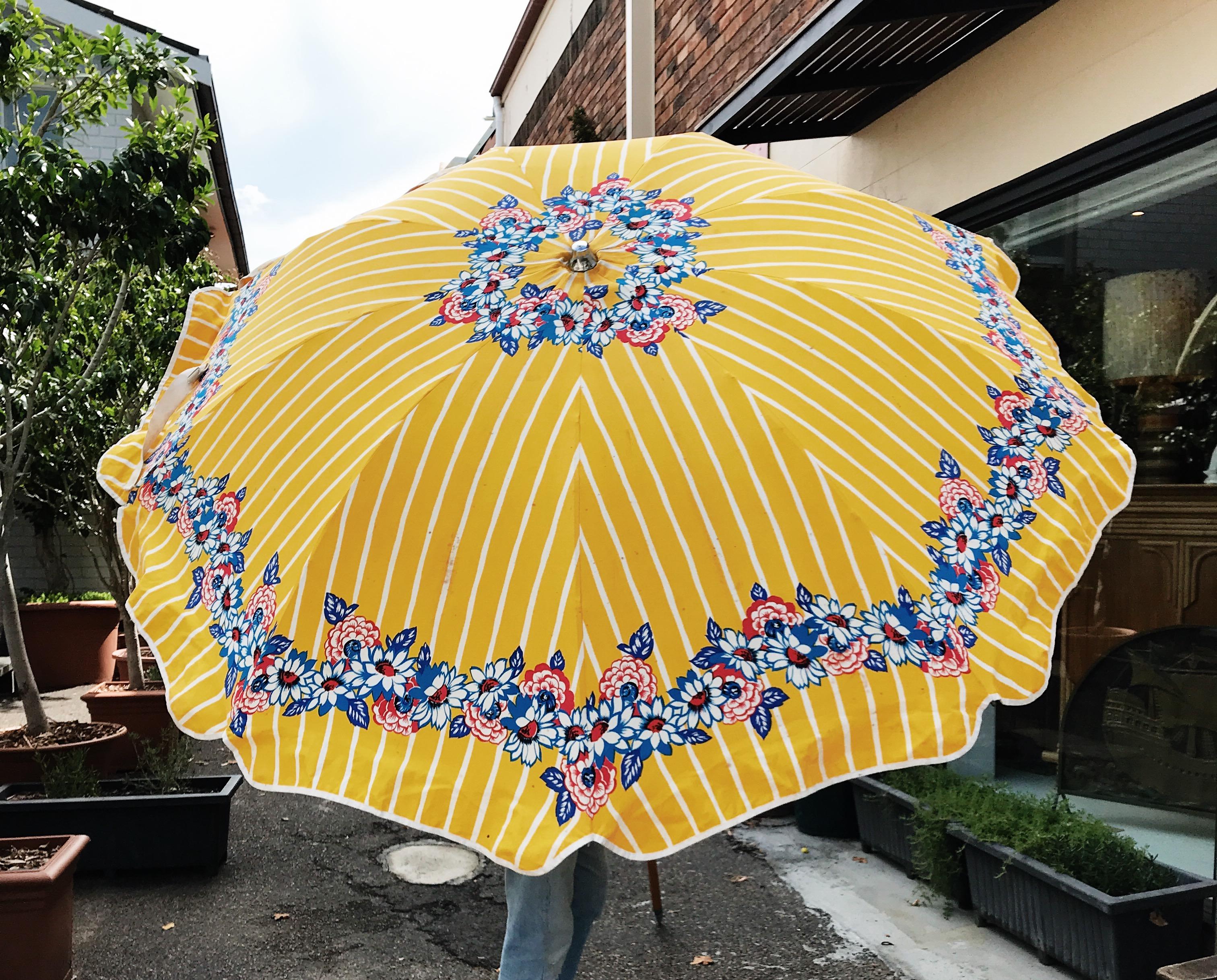 Marvellous 1960s vintage, floral and striped cotton beach umbrella, by renowned Australian outdoor umbrella company, Shelta.

This one has a built in bottle opener at the elbow of the wood and metal pole. A vital inclusion for any sunny afternoon
