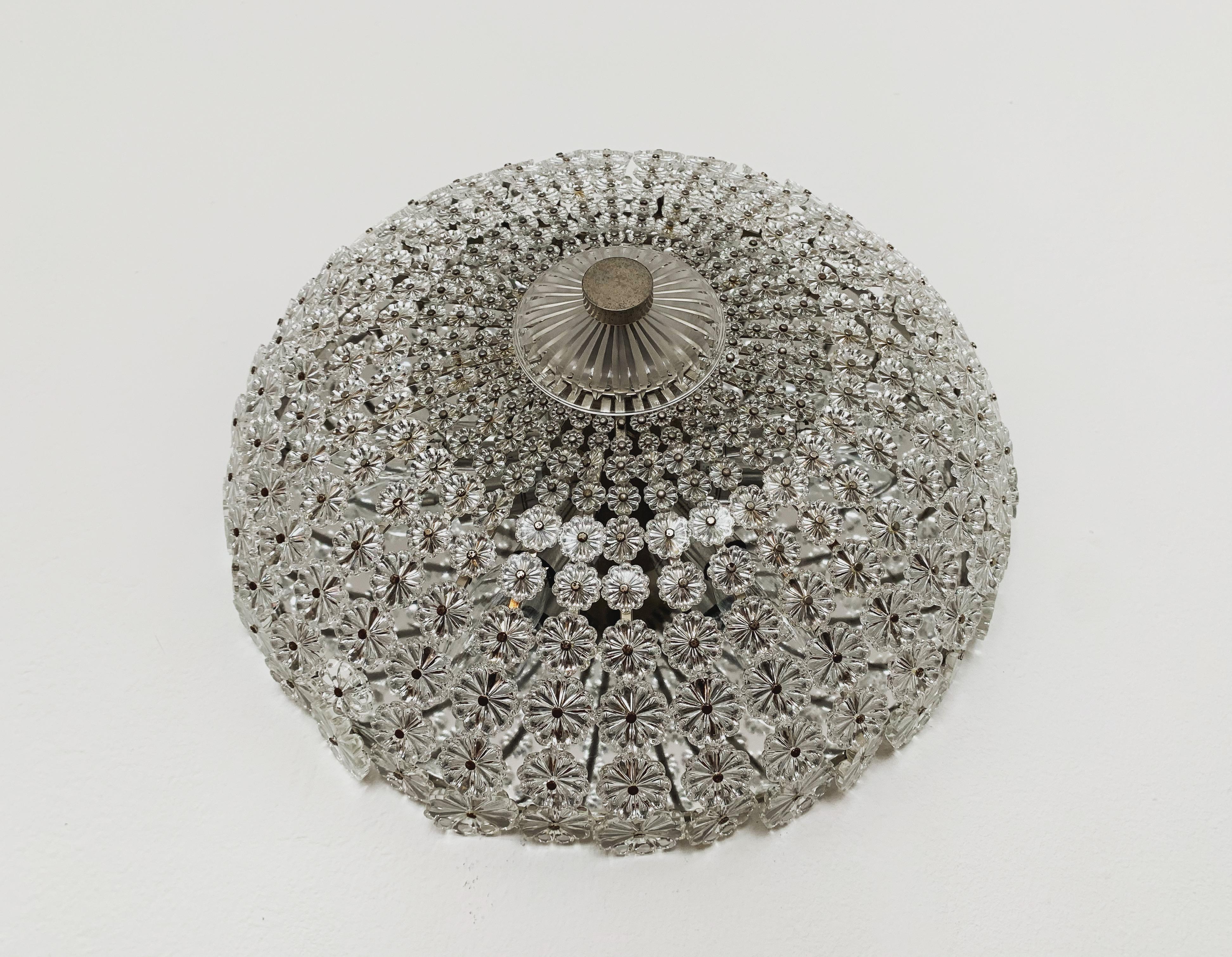 Splendida lampada da soffitto in cristallo degli anni '60.
La lampada, con i suoi fiori riccamente decorati e i dettagli in ottone, ha un aspetto molto lussuoso e brilla in modo particolarmente bello.
Il design e i materiali utilizzati creano una