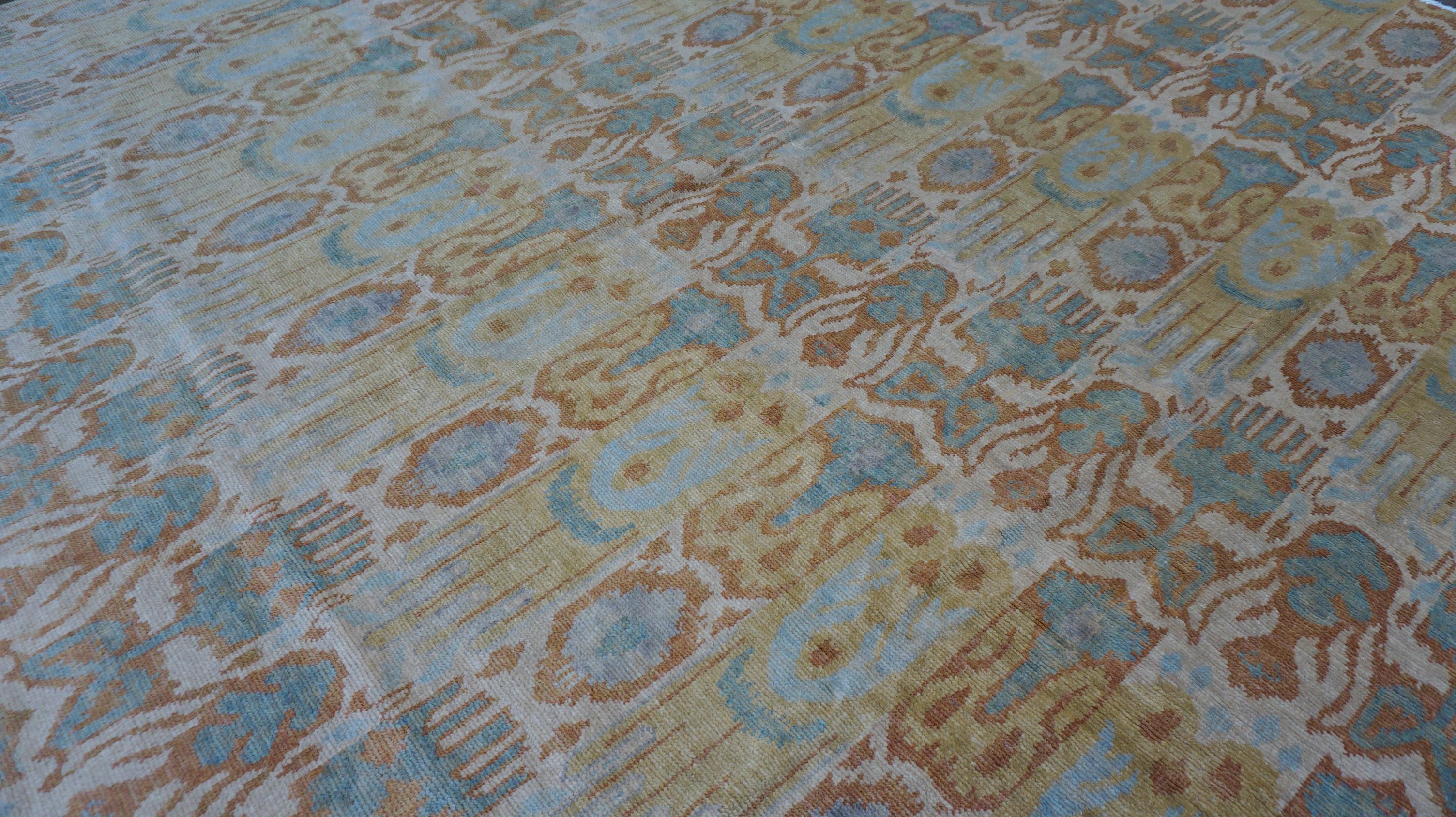 Ce superbe tapis en laine noué à la main présente une version vibrante et contemporaine des motifs textiles traditionnels, avec un design inspiré de l'ikat dans une palette de jaune, de bleu et de vert. Le tapis présente une disposition rythmée et