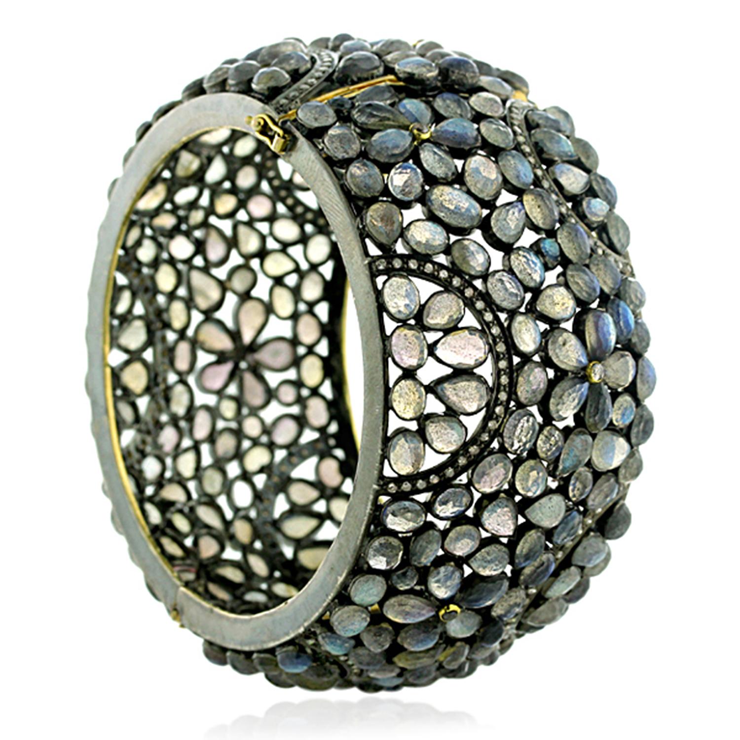 Bold and gothic looking Floral deisgn Labrodorite Cuff with Diamonds made in silver. This bangle is openable on side and has safety clasps on side.

14k: 4.25gms
Diamond: 1.6ct
Slv:32.89gm
Labradorite: 200.00ct

