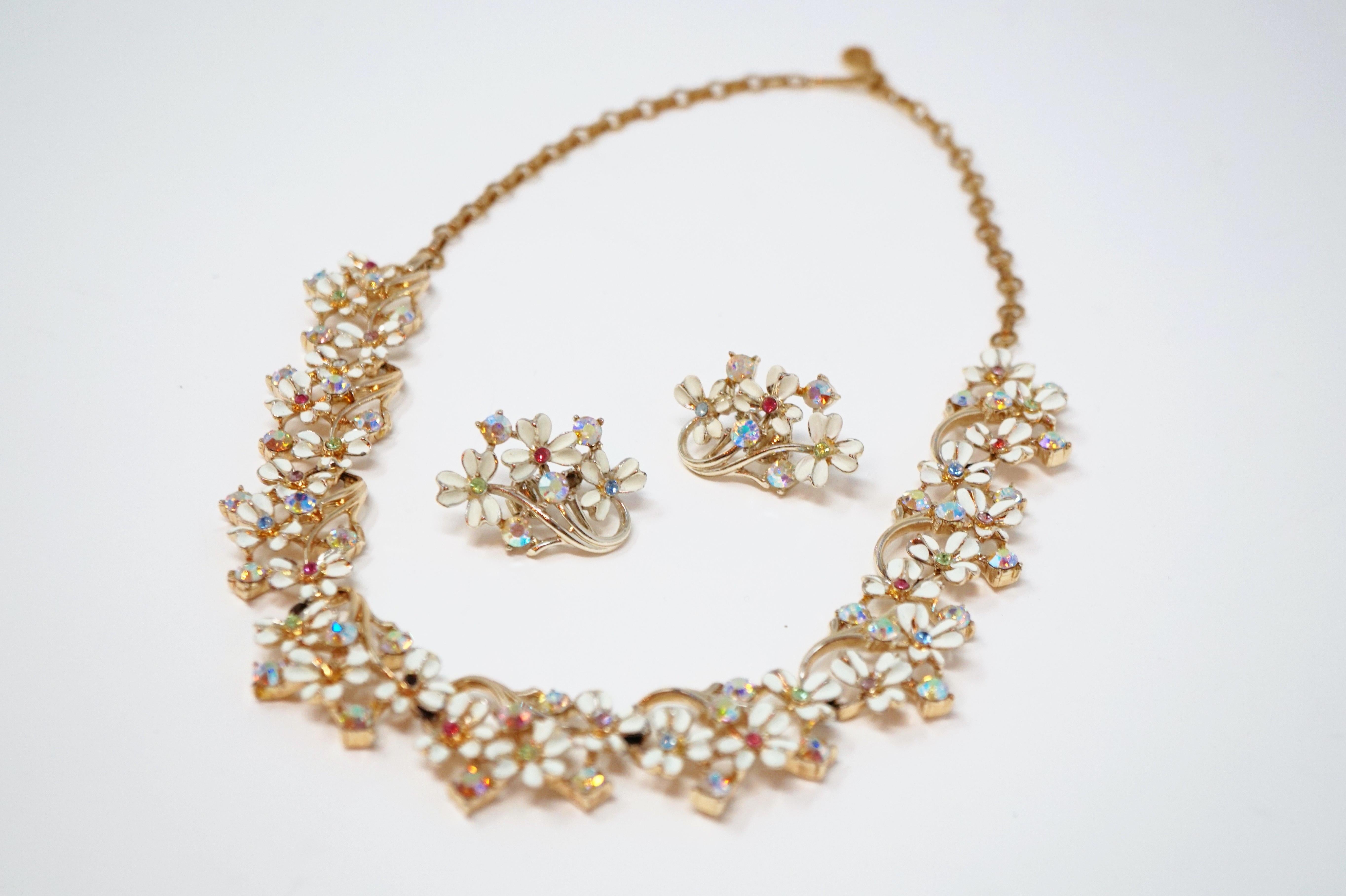 This rare and stunning demi-parure necklace and earring set by Coro, circa 1960s, is absolutely dreamy!  White enameling and pastel Aurora Borealis crystals decorate a bouquet of gilded flowers in this rare treasure from the iconic vintage costume