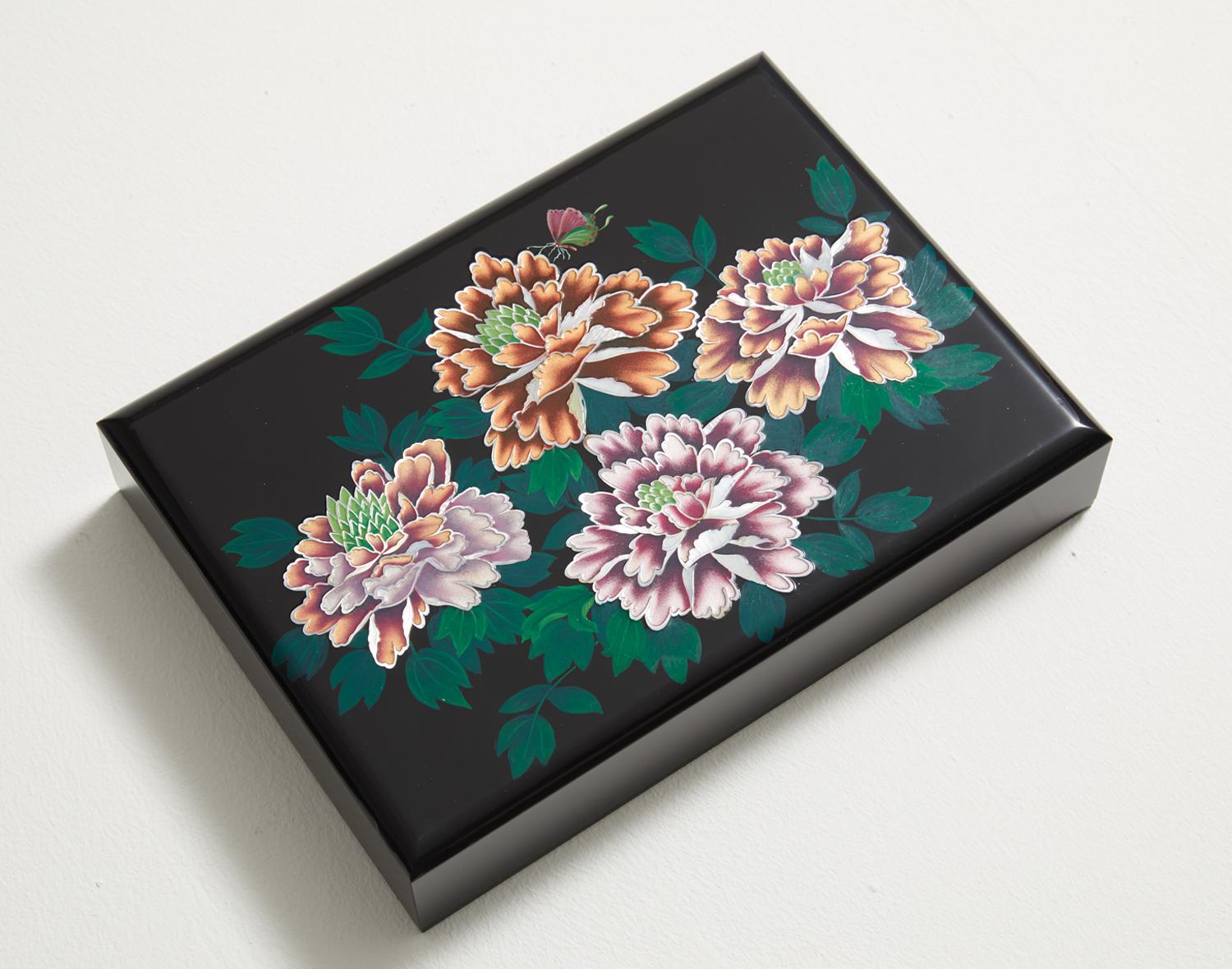 This artwork adopts mother of pearl and lacquer to portray peony blossoms, also known as the king of all flowers and a symbol for beautiful women. The lustrous mother of pearl was used to create such sumptuous flower patterns. The colors inside the