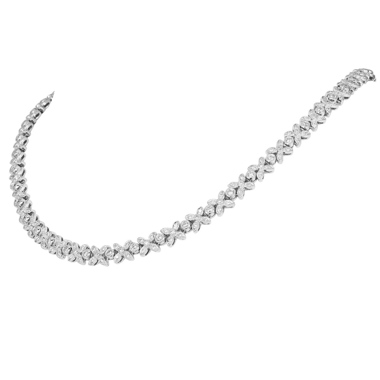 An elegant floral tennis necklace, this 18K white gold design features a repeating four-leaf floral motif adorned with natural round diamonds totaling. Each link is precisely crafted for fluid movement and a smooth finish that sits comfortably along