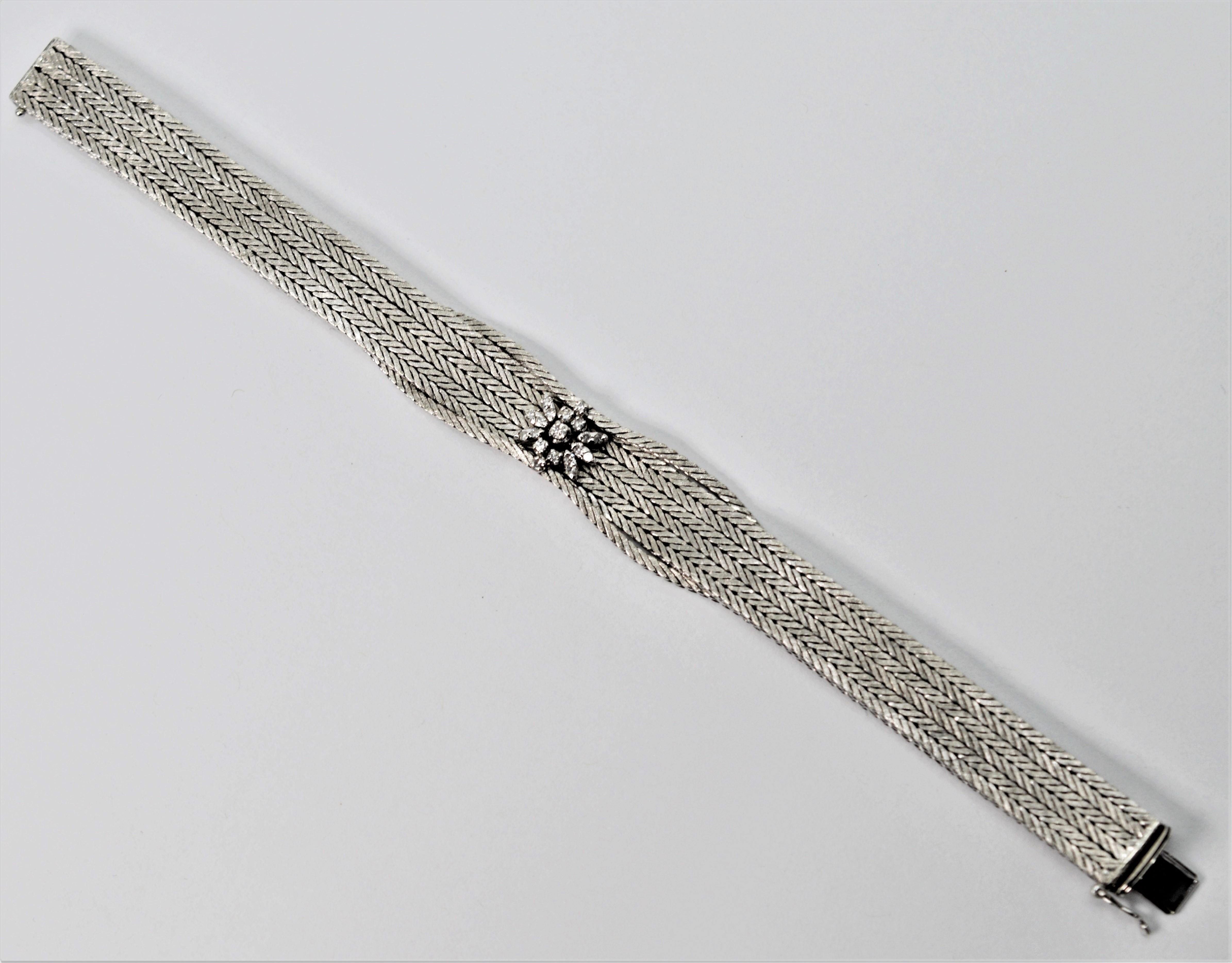 Petals of diamonds create the floral focal point of this stunning eighteen karat 18K white gold chain bracelet. Expert Italian craftsmanship is reflected in the meticulously woven satin white gold herringbone patterned chain that is married to form