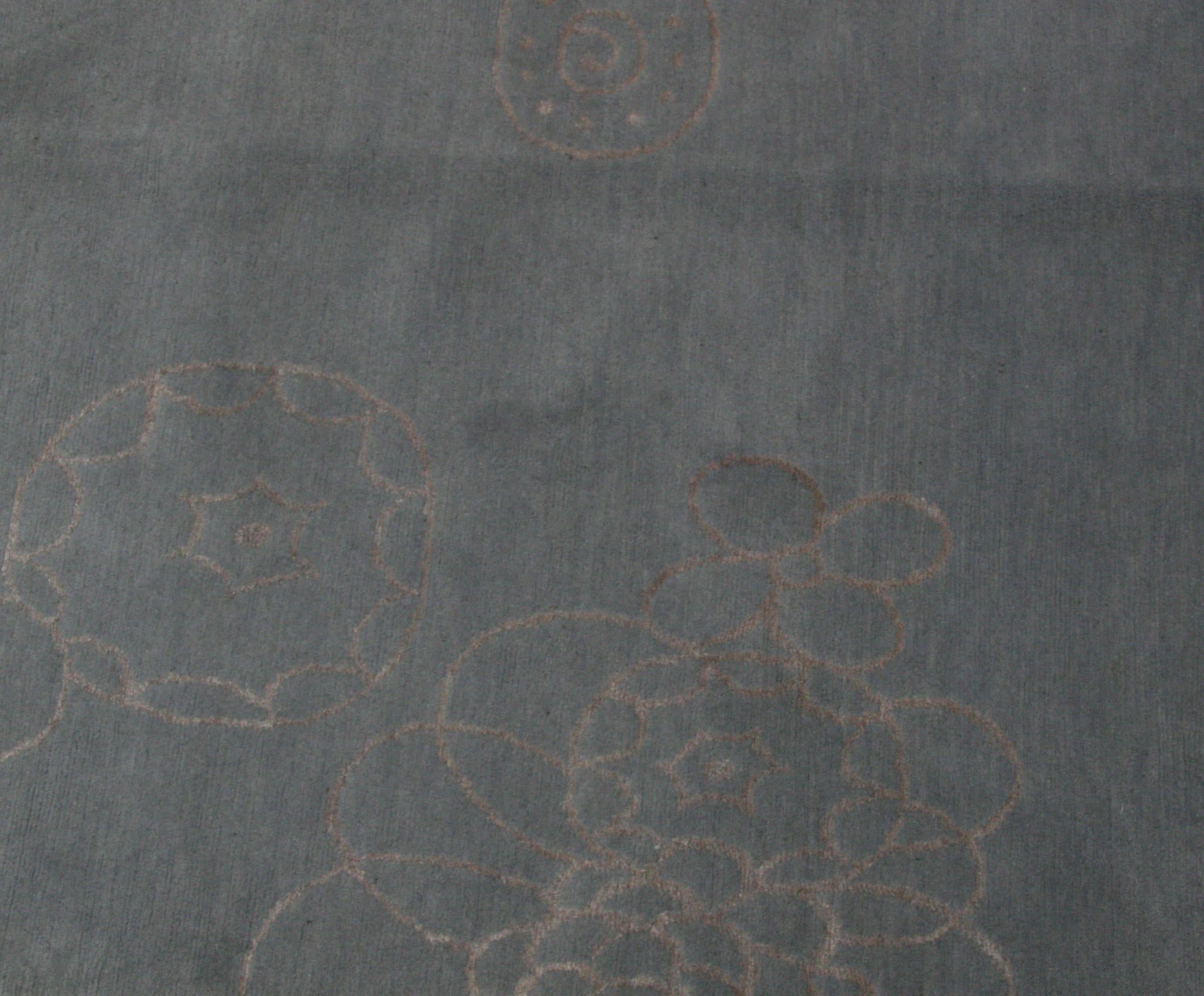 Hand-drawn flowers seem to float effortlessly across a dark gray base in this whimsical contemporary Tibetan design rug. The wool/silk blend makes for a lustrous texture that is also provides durable comfort under foot. Hand-knotting creates 'light'