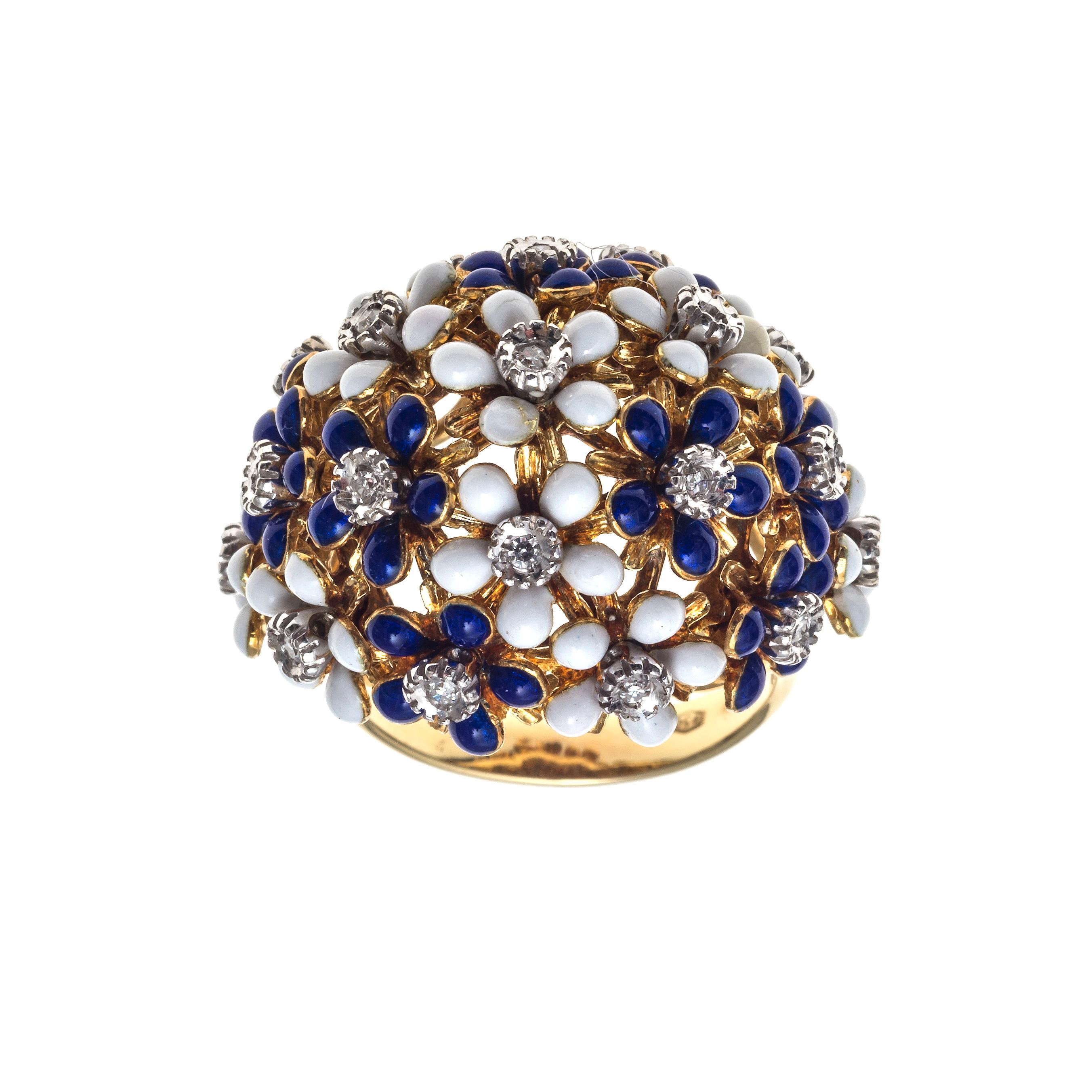 Blue and white enamelled floral domed cocktail ring made out of 18K yellow gold. Ten white enamelled flowers alternate with nine navy blue enamelled flowers. Each flower has a white gold center set with a small diamond. Each enamelled flower petal