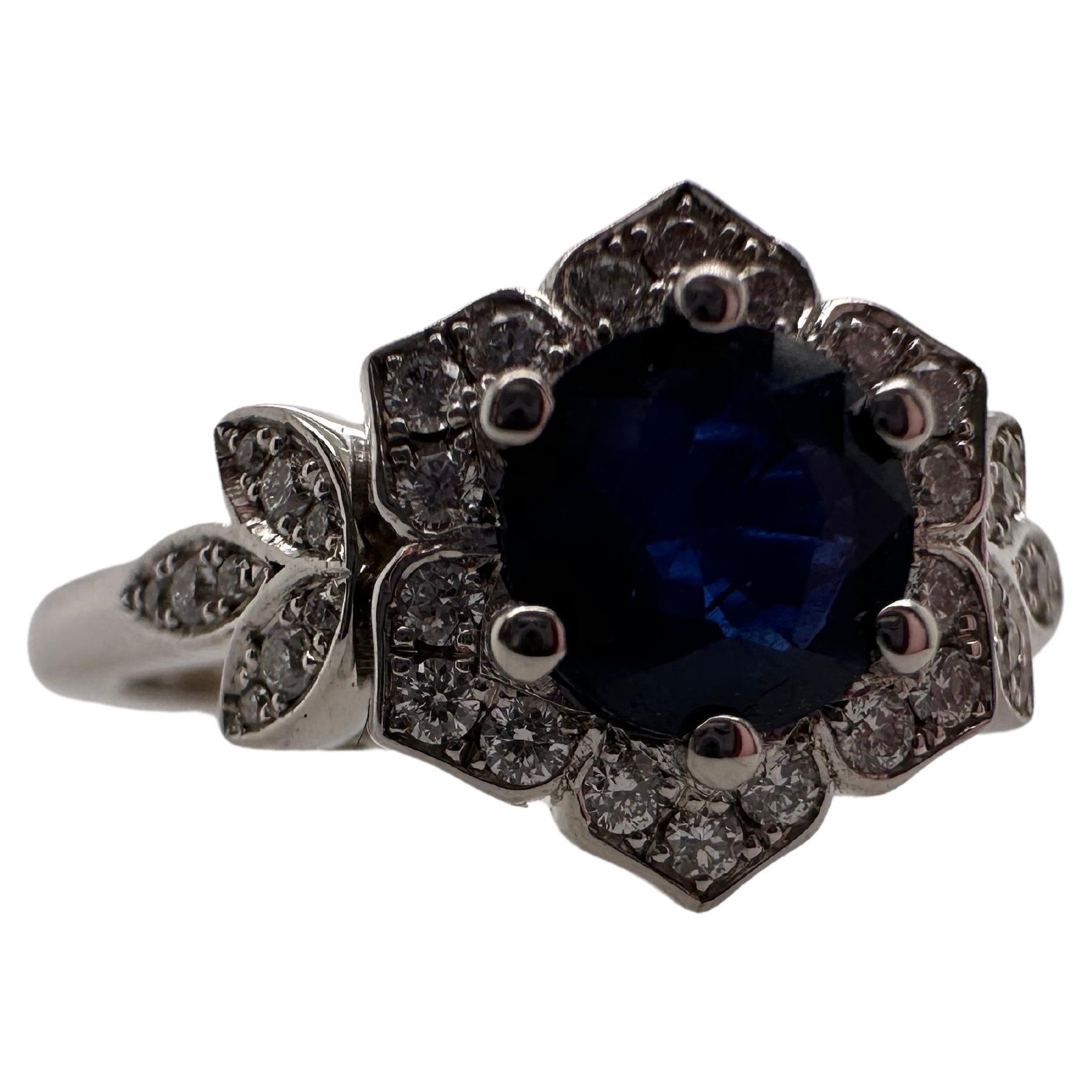 What a unique piece, artist unknown on this floral beauty! The center is a blue sapphire weighing 1.02 carats, white diamonds are superb at VS clarity and F color, the ring is a size 6 and can be re-sized.

Metal Type: 14KT

Natural